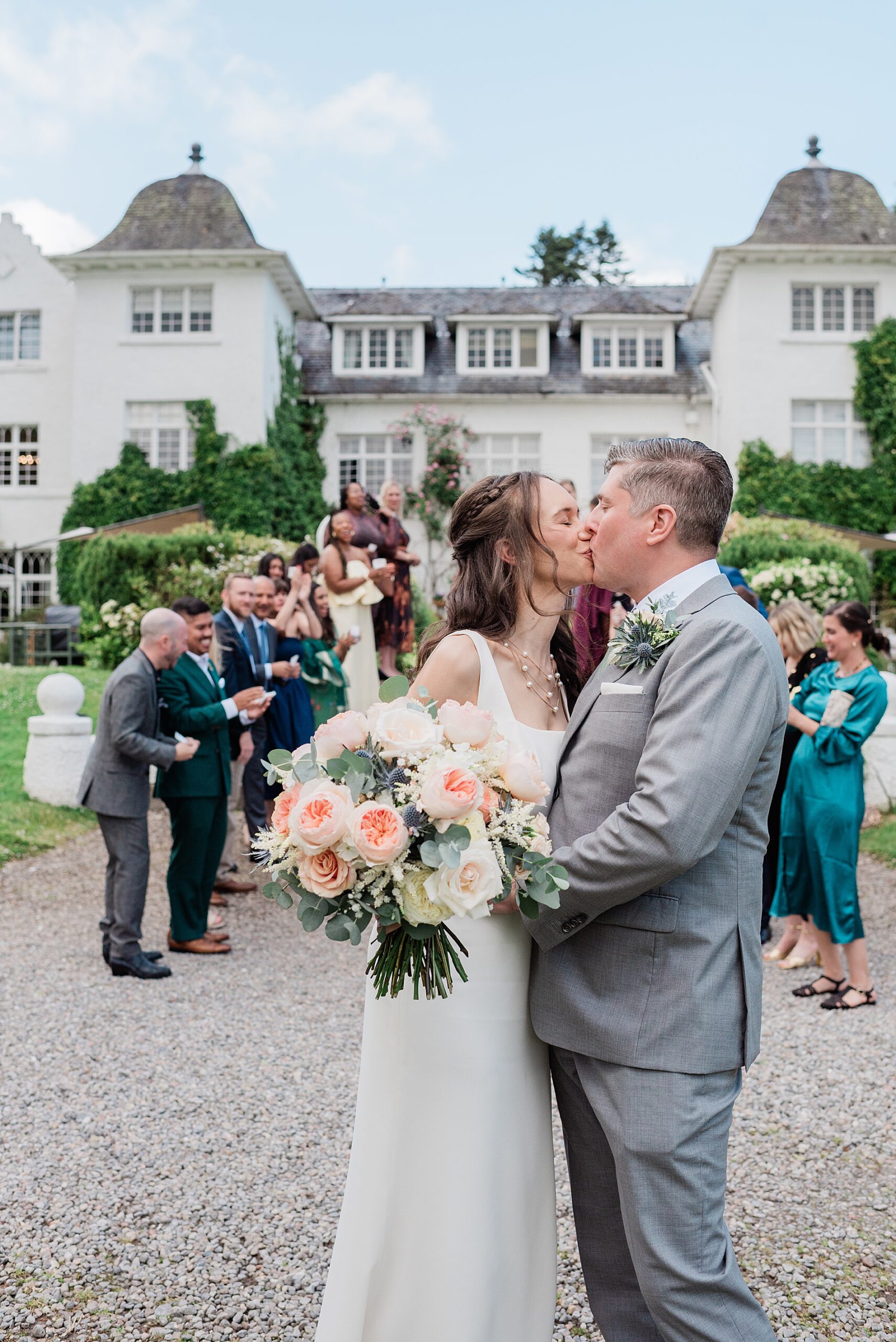 Newlyweds kiss outside of Achnagairn Castle in Scotland 