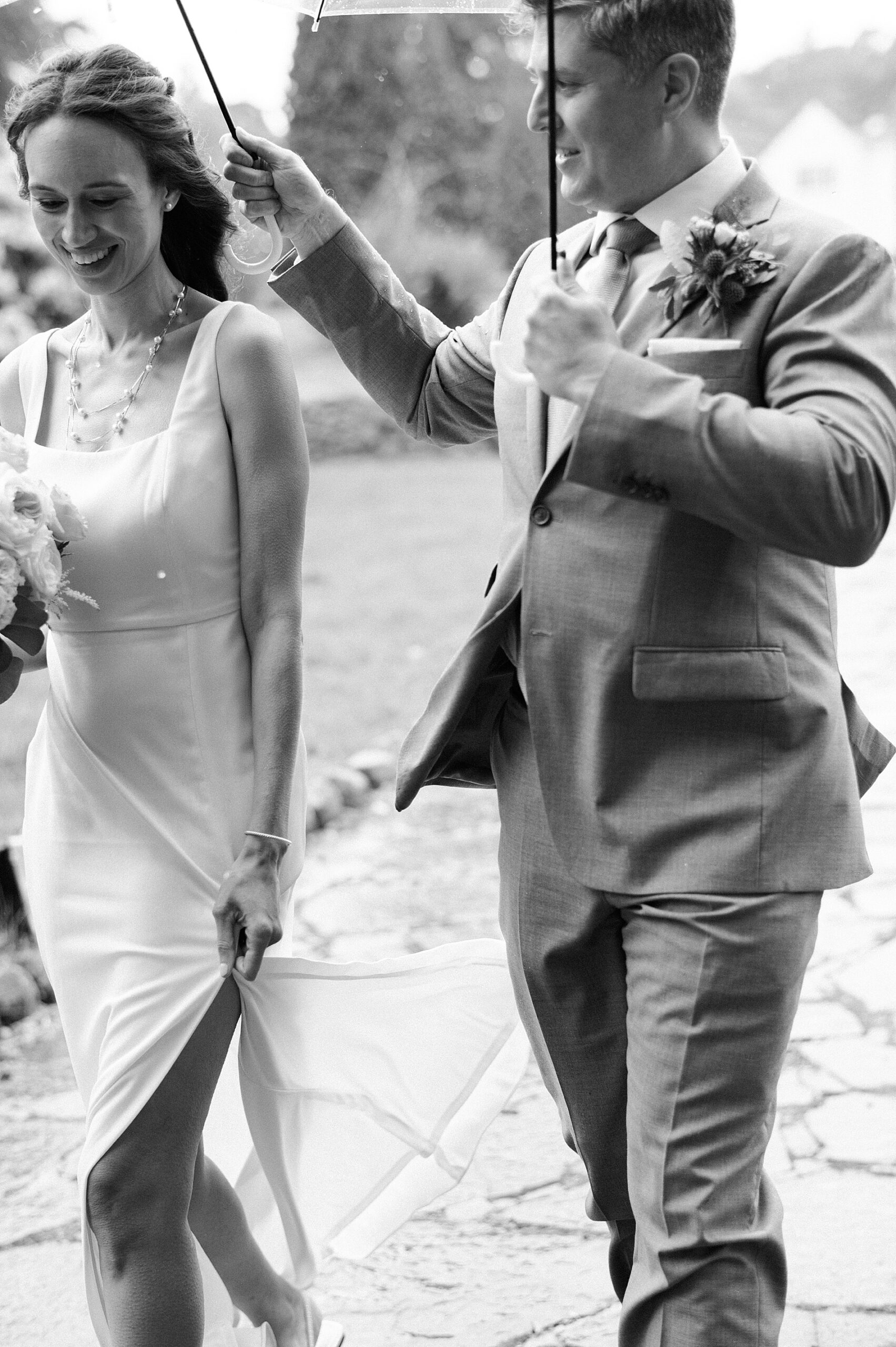 groom holds umbrella over bride 