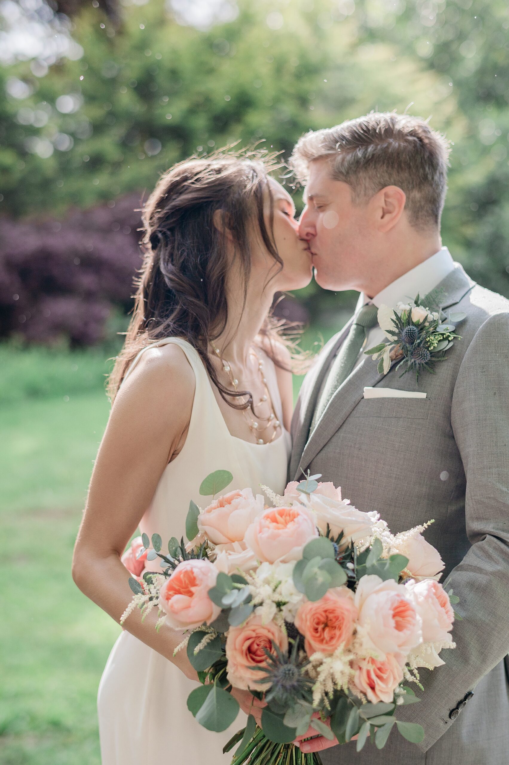 Newlyweds kiss during wedding portraits 