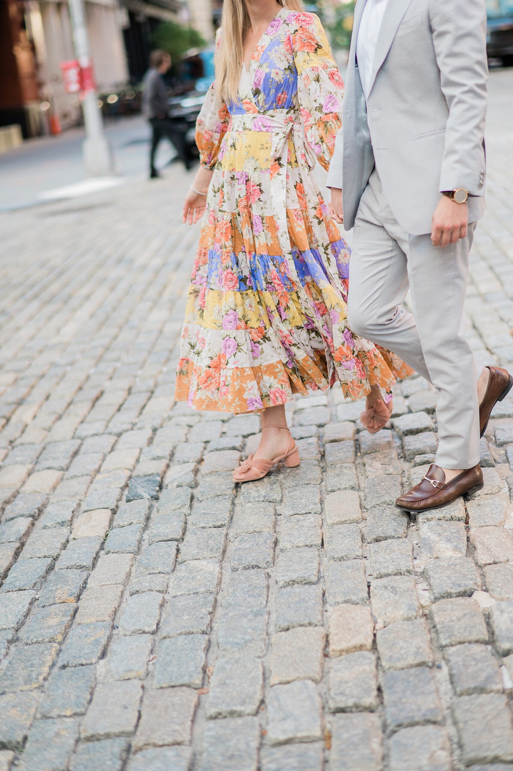 woman in colorful, flowy floral dress and man in grey suit