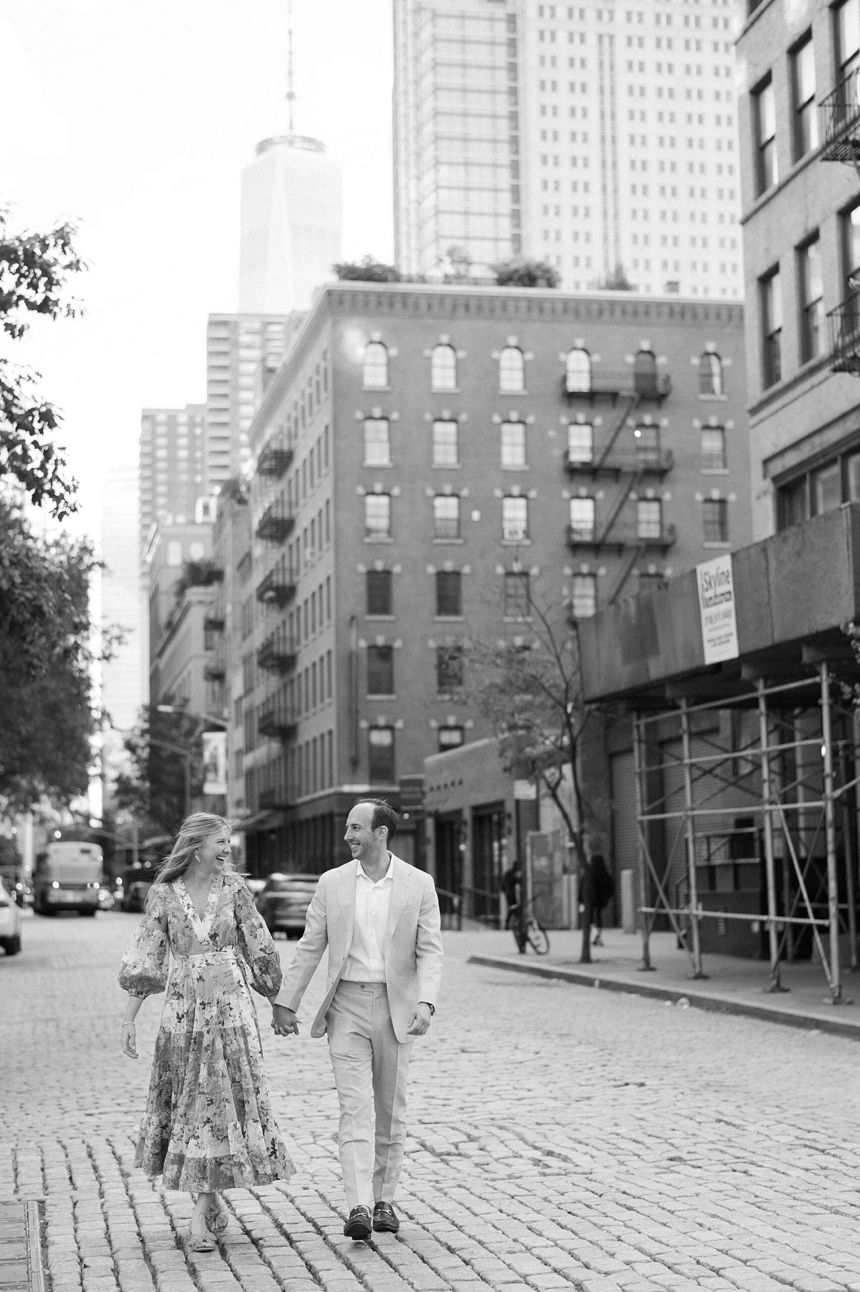couple holds hands as they walk down street