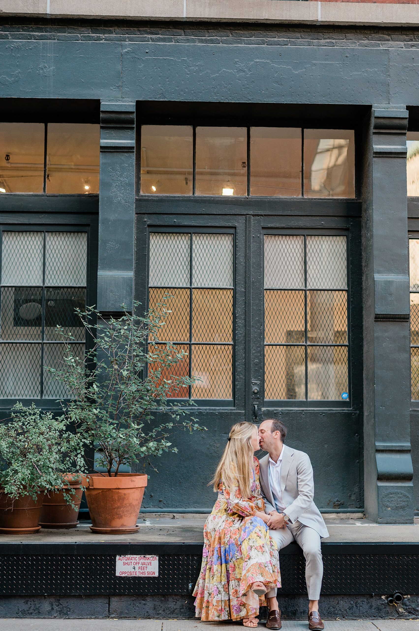 couple sit in front of building 