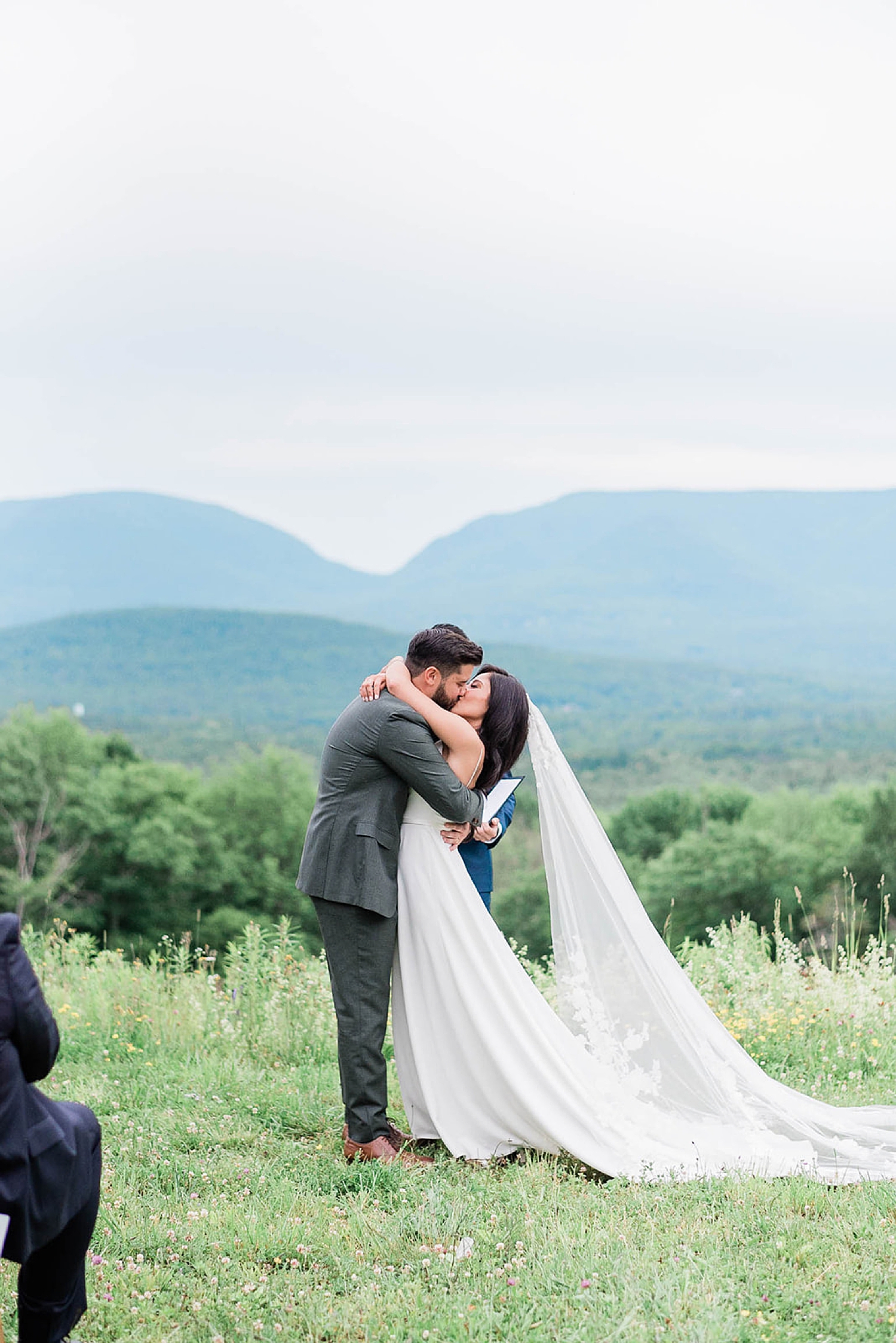 bride and groom kiss on top of mountain at wedding ceremony