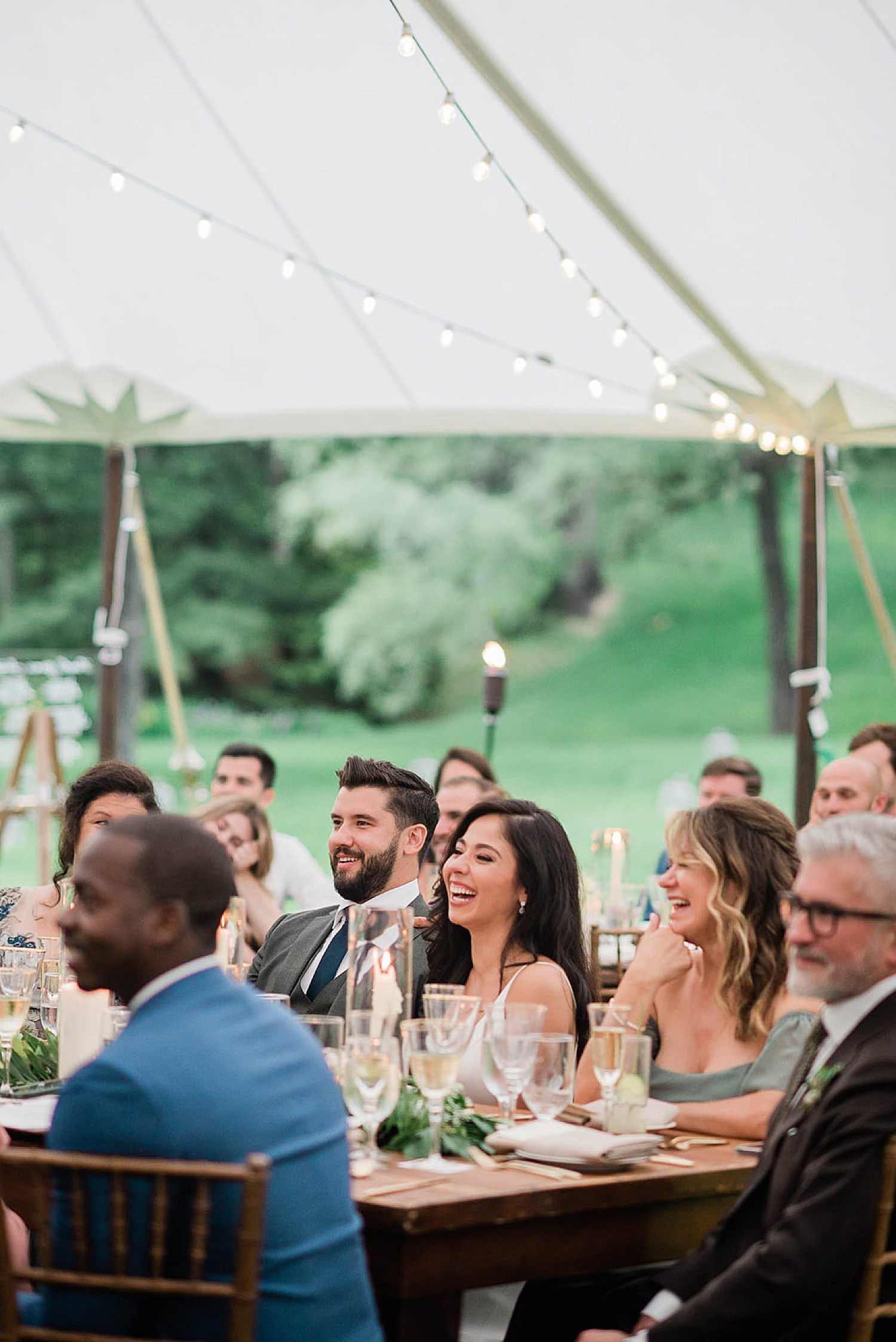 candid portraits of newlyweds and guests laughing during wedding toasts