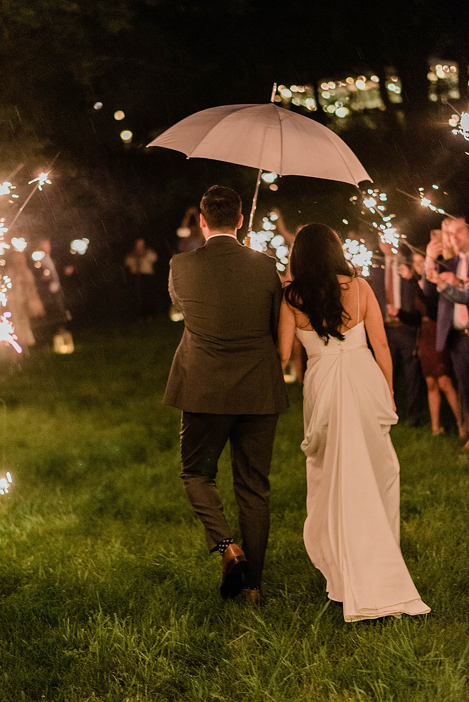bride and groom exit wedding with guests holding sparkers