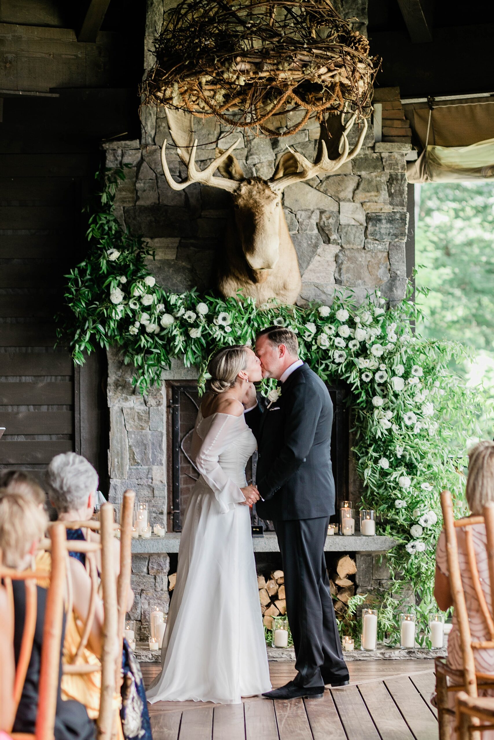 bride and groom kiss at wedding ceremony at Lake Placid Lodge
