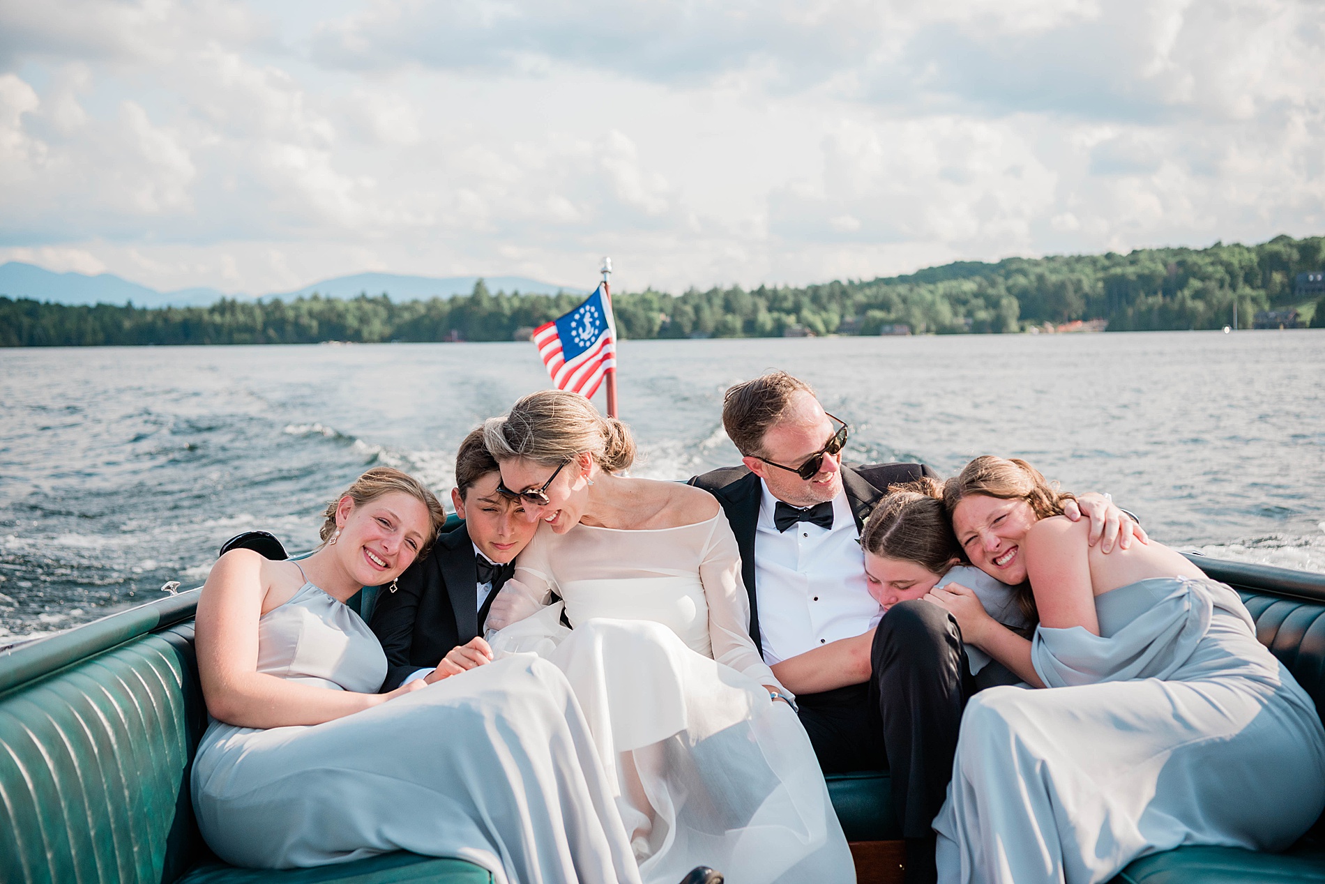 family photo of bride and groom with their kids on a boat after Lake Placid Wedding ceremony