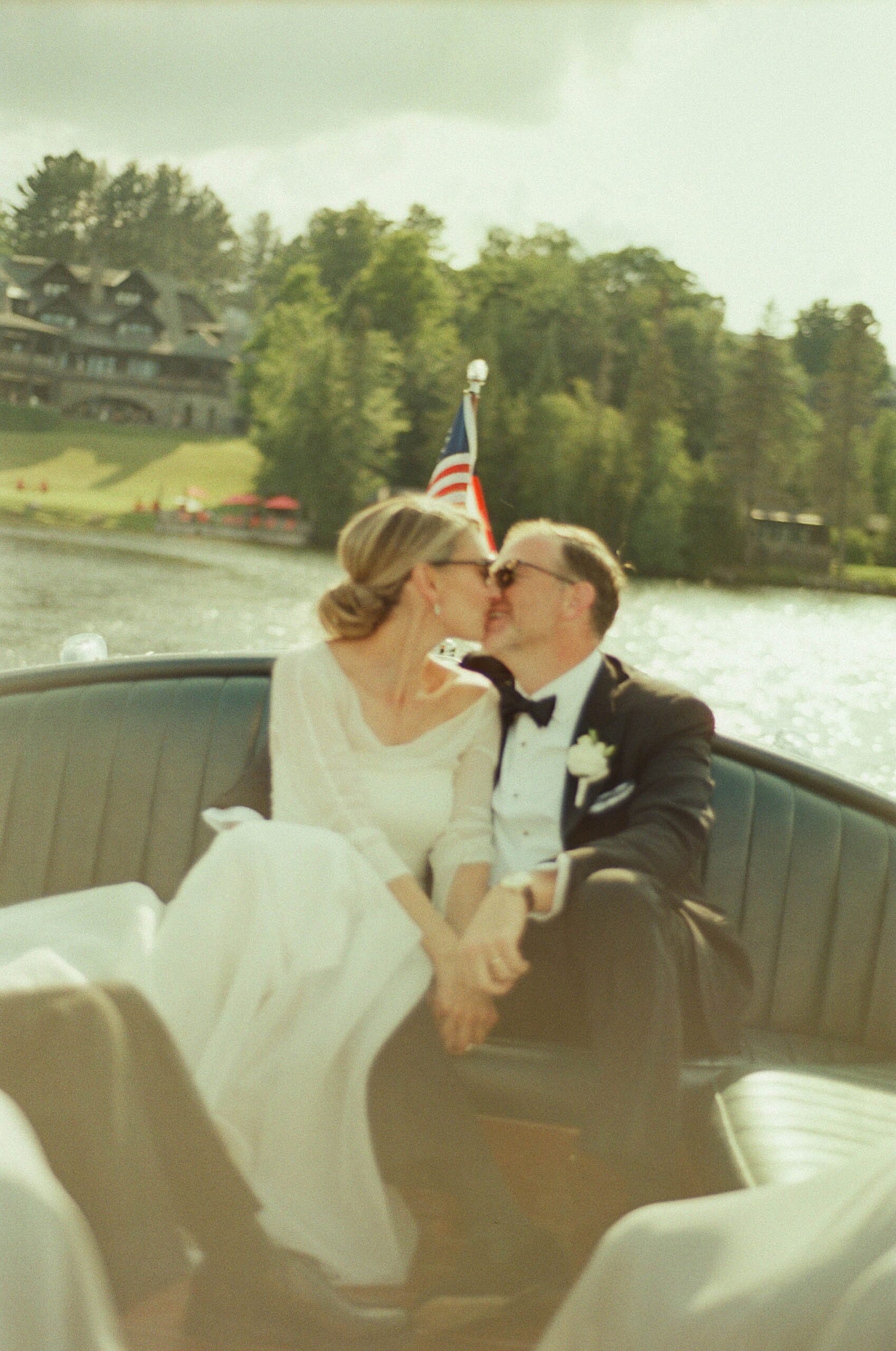 newlyweds kiss on Lake Placid boat ride