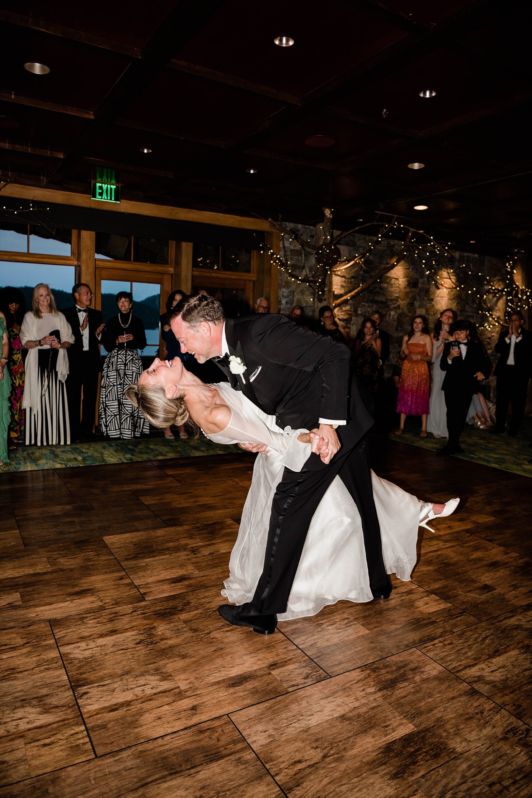 candid and joyful wedding photos of groom dipping bride on dance floor