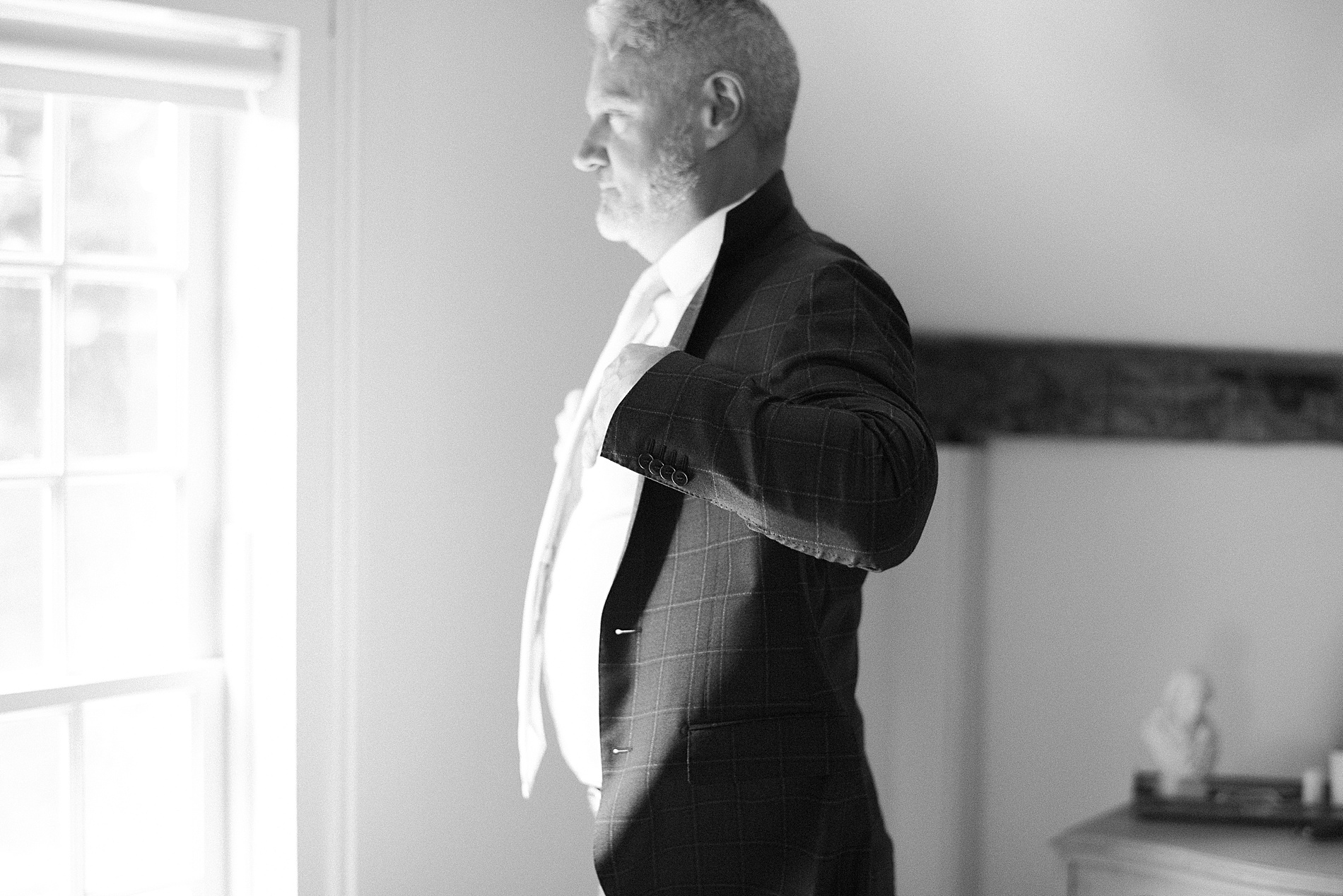 groom putting on suit jacket