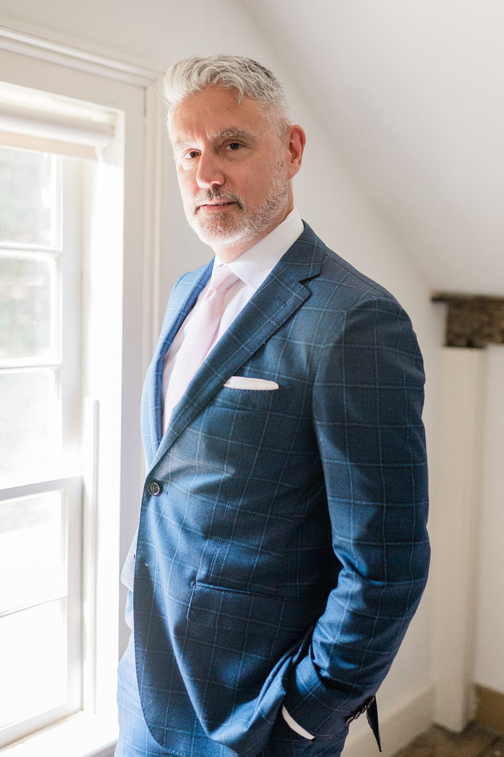 groom in blue suit with light pink tie