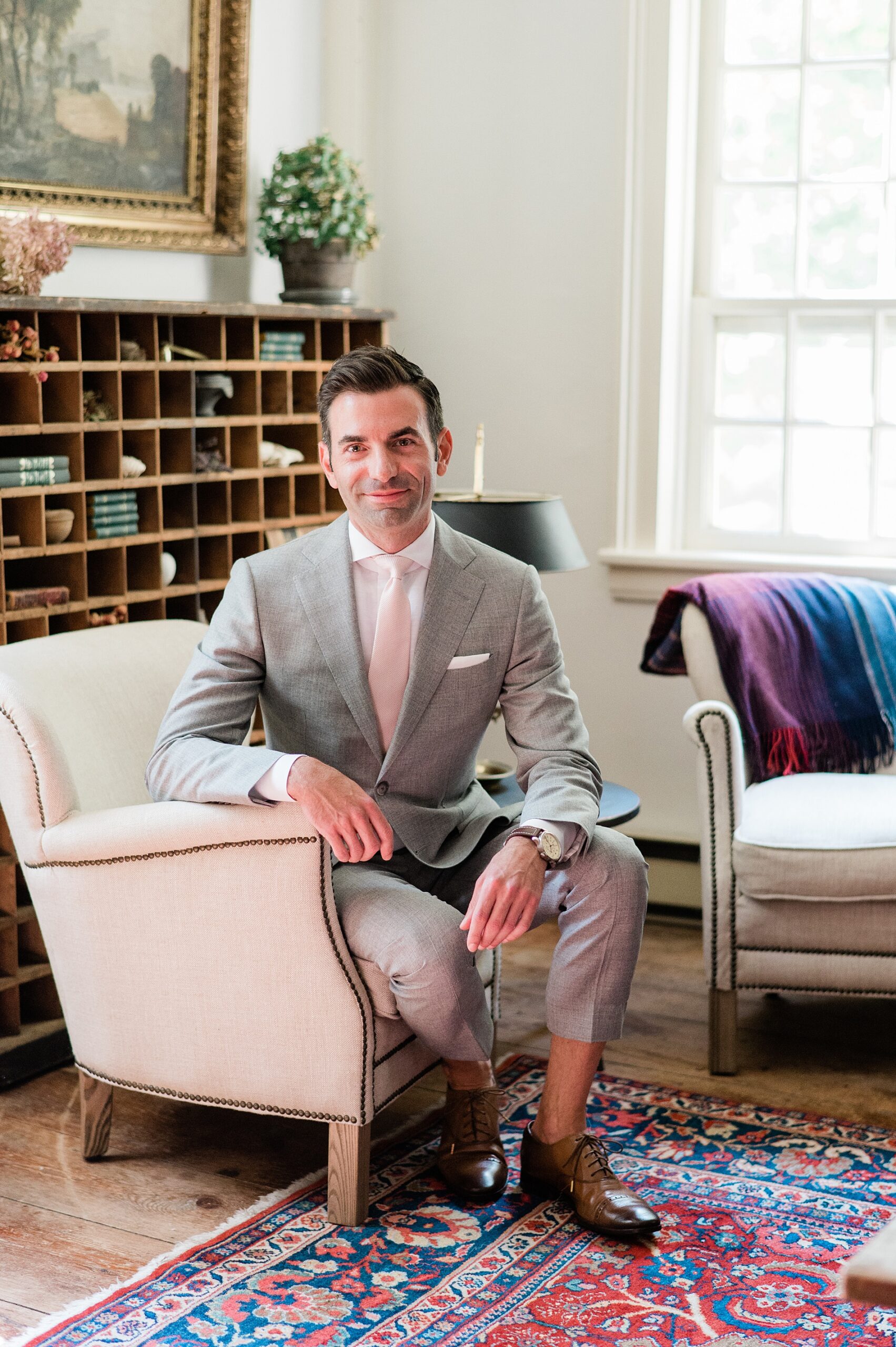 groom sitting in chair in bedroom