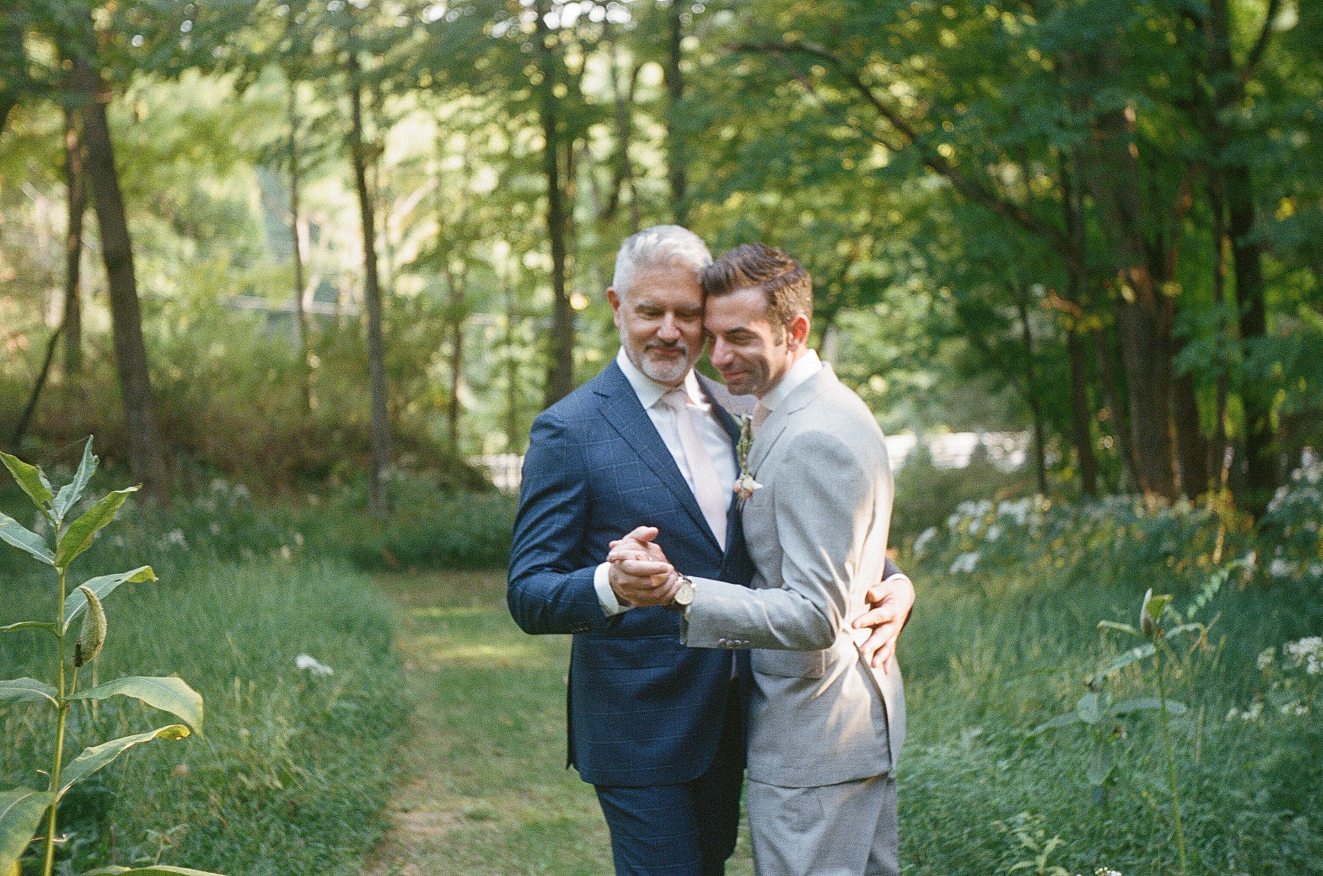 couple share private moment together as they dance in a clearing of tall grass
