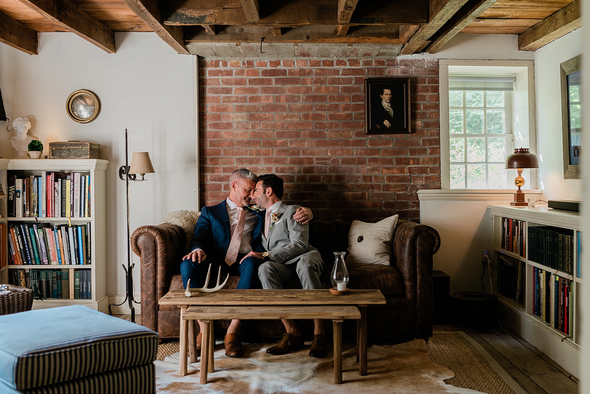 wedding photo of grooms sitting on couch in their home
