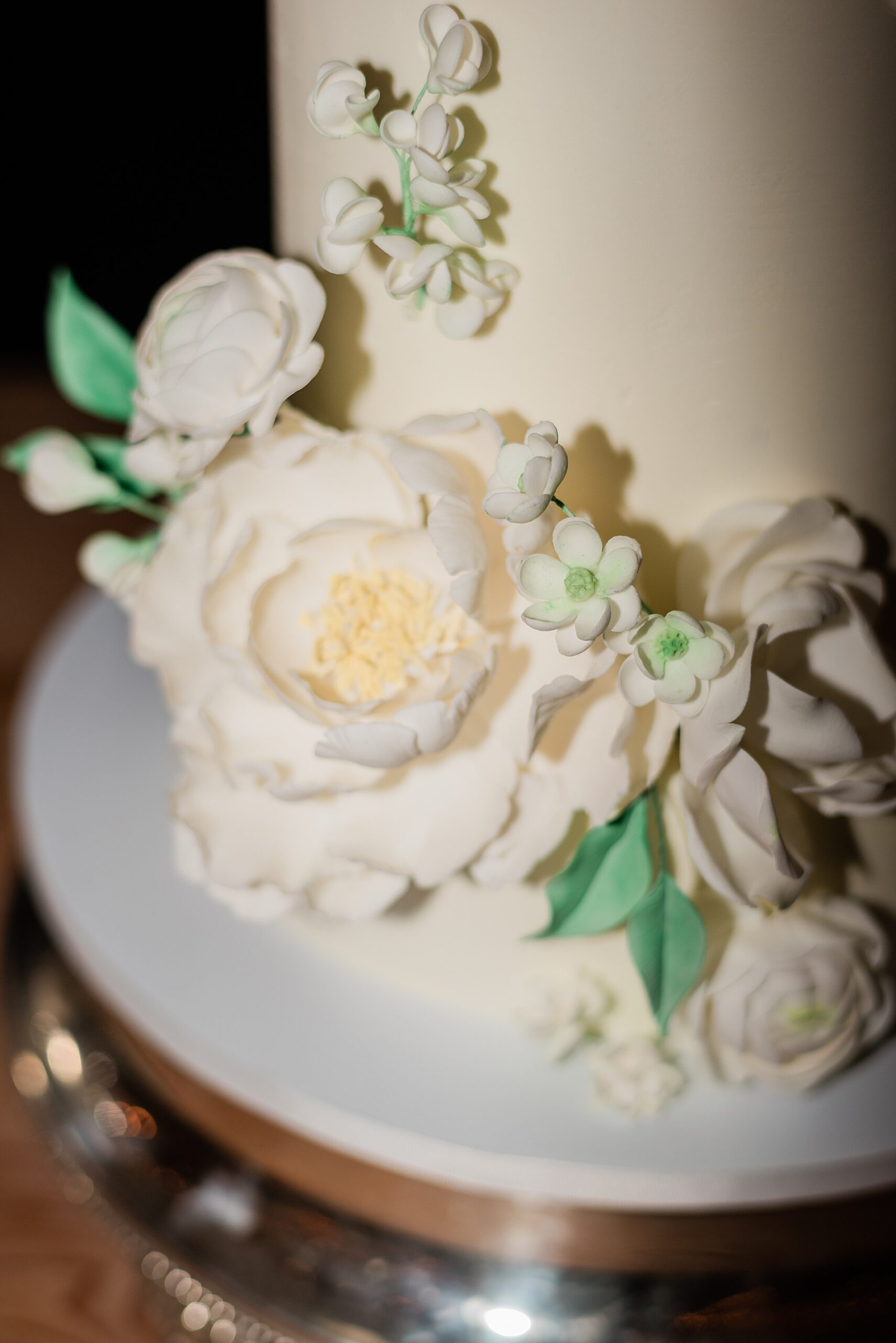 close up florals on wedding cake made of icing