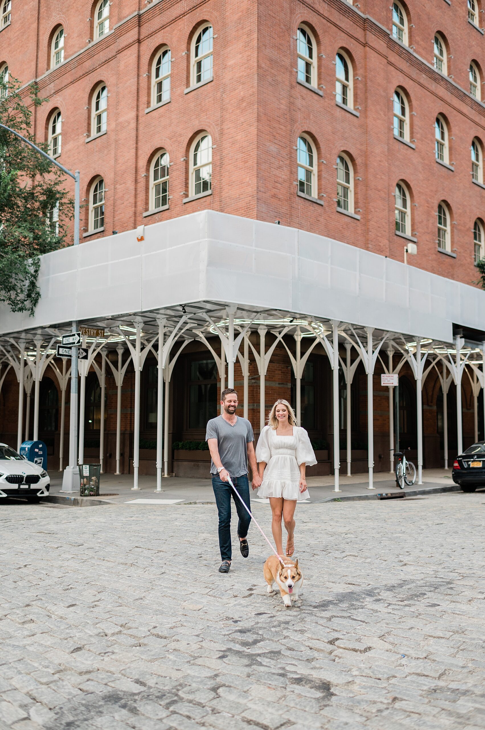 couple walk their dog during engagement session in Tribeca