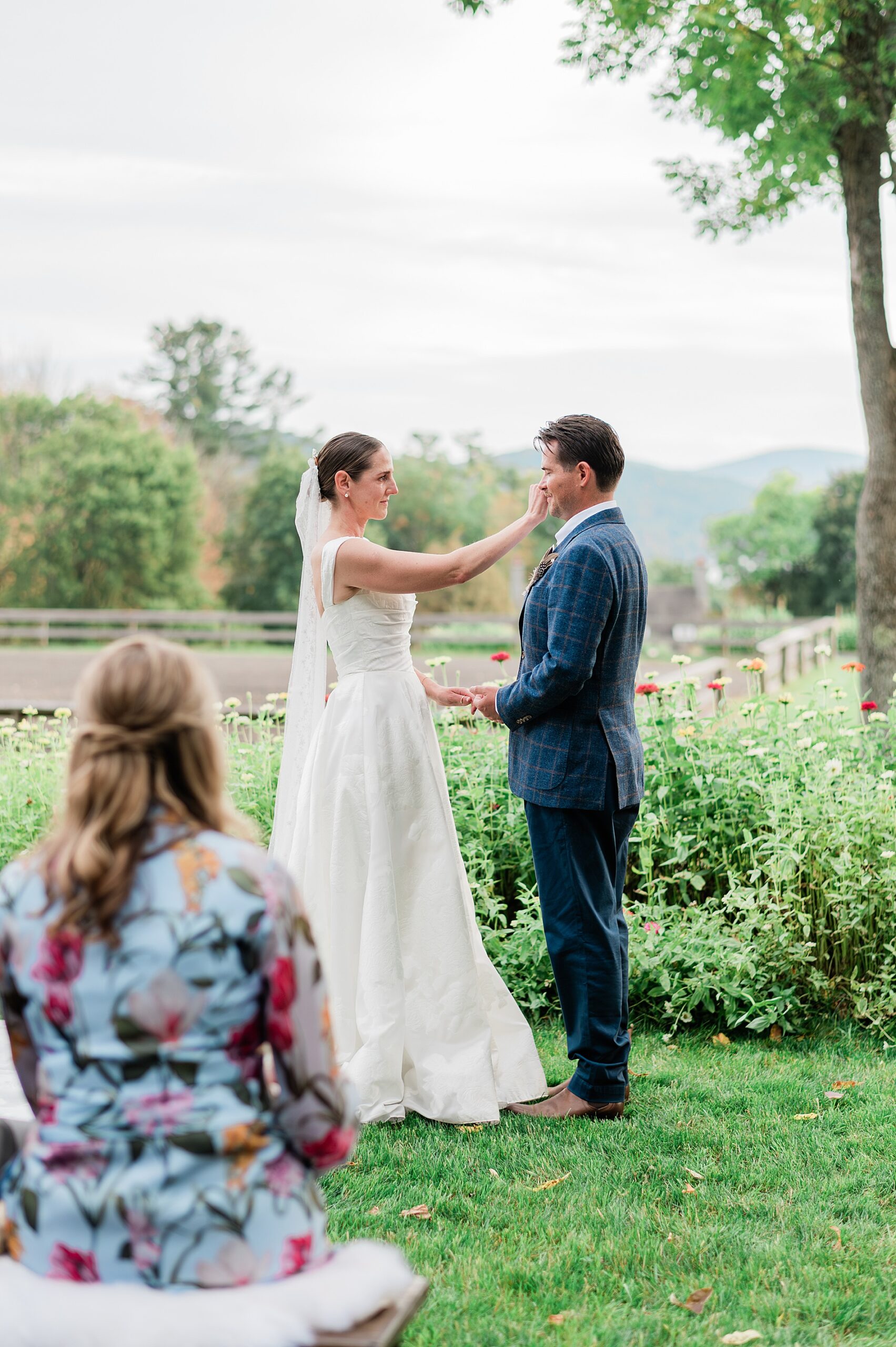 bride wipes away groom's tears during wedding ceremony