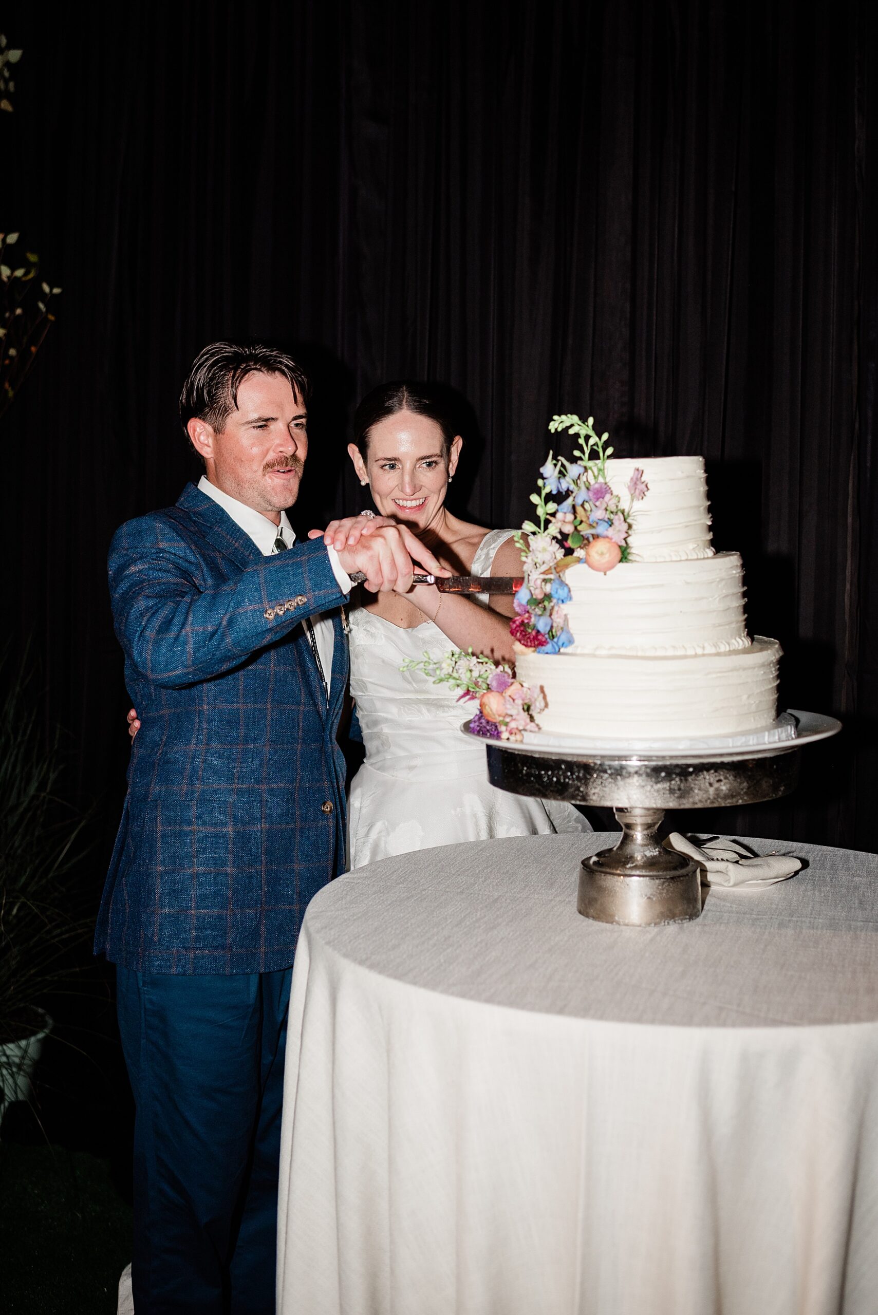 bride and groom cut wedding cake