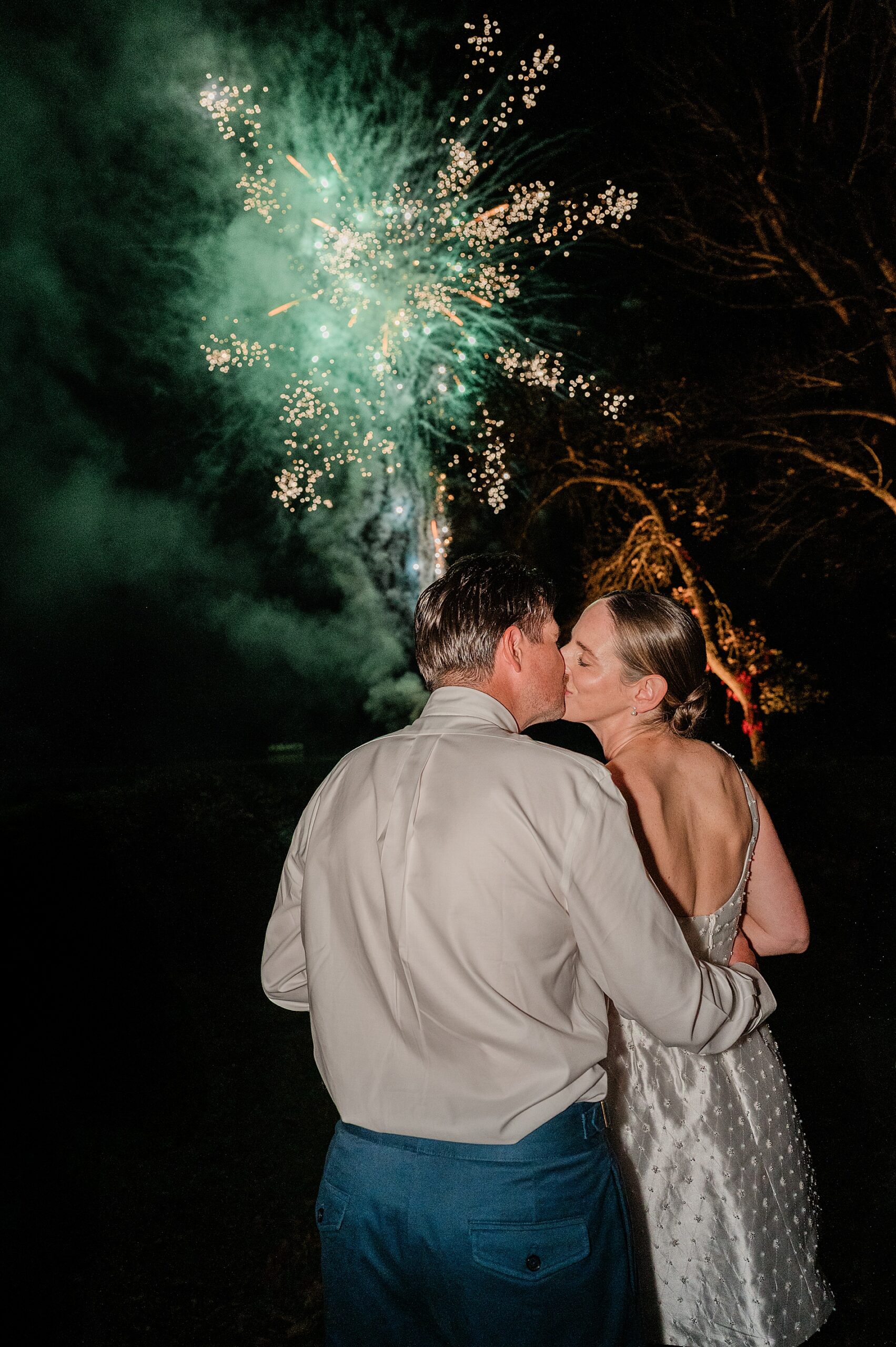bride and groom kiss as they watch fireworks at Private Estate Wedding in New York