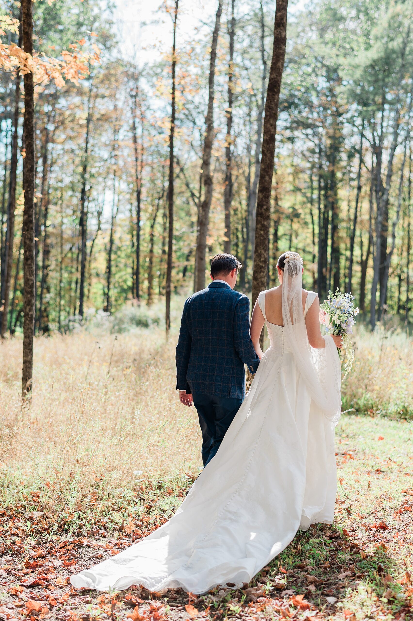 couple walk together in the woods on family property