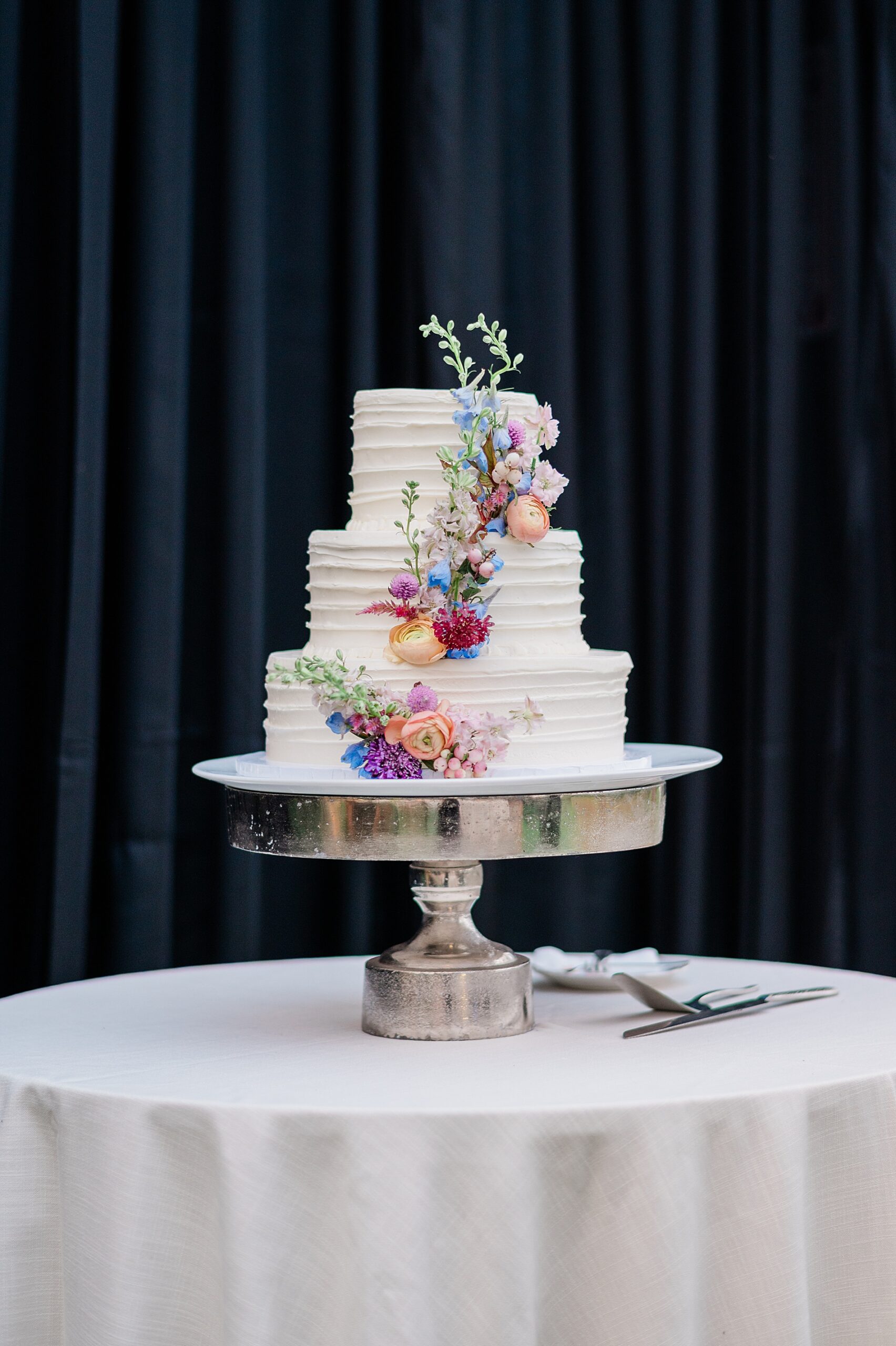 white wedding cake with flowers running along cake