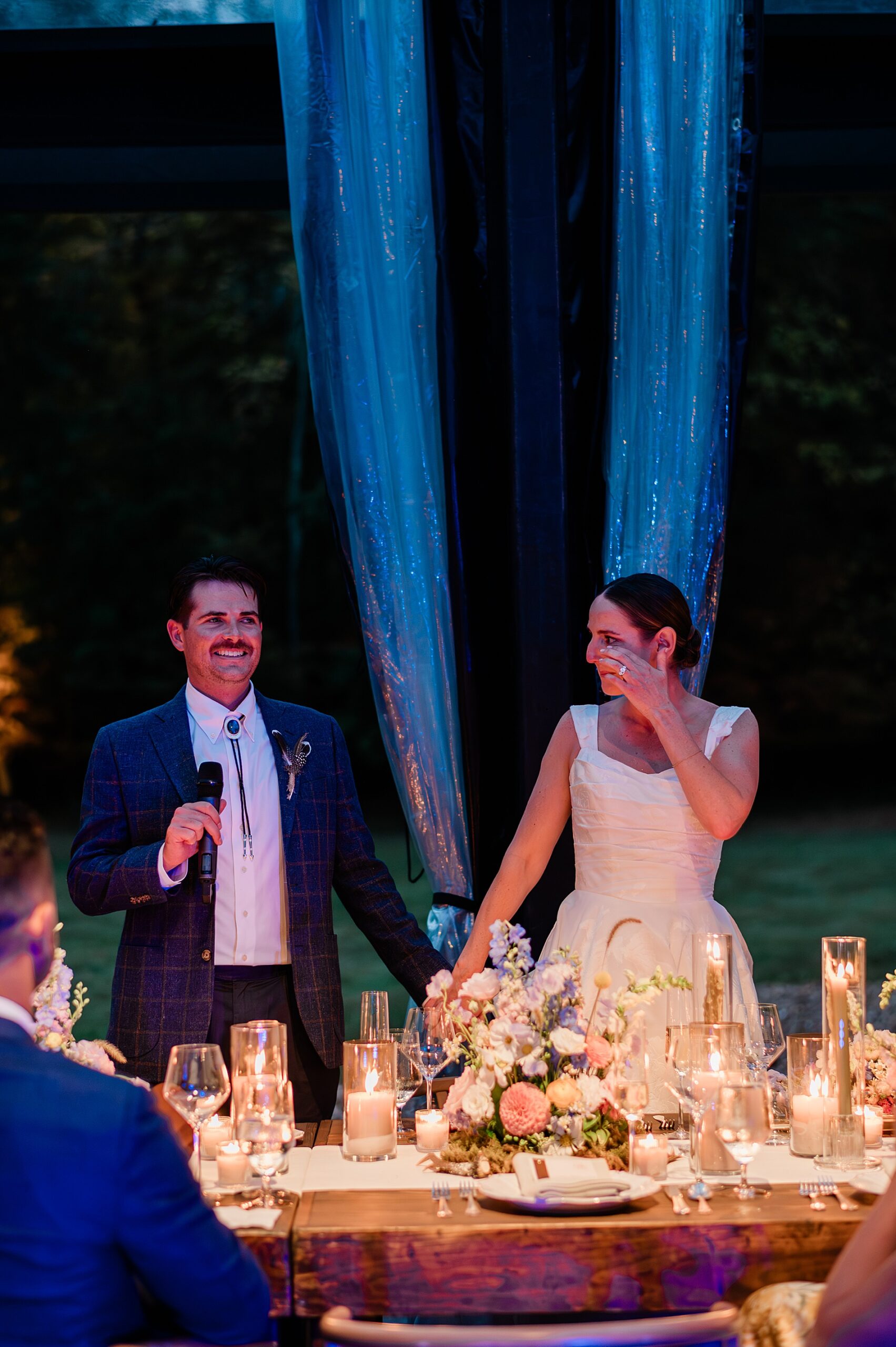 bride wipes away tears as her and groom thank everyone