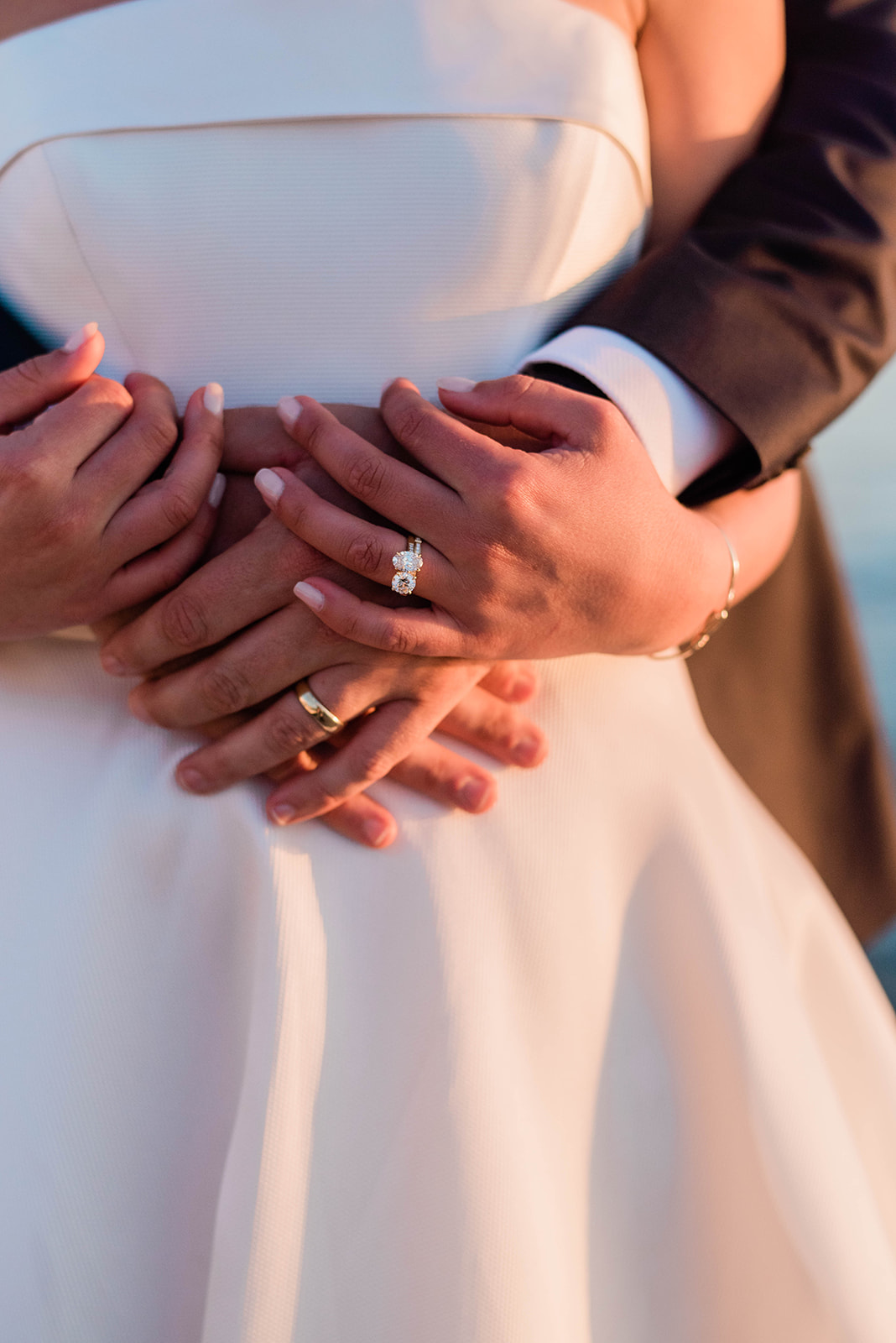 bride and groom holding hands with wedding rings 