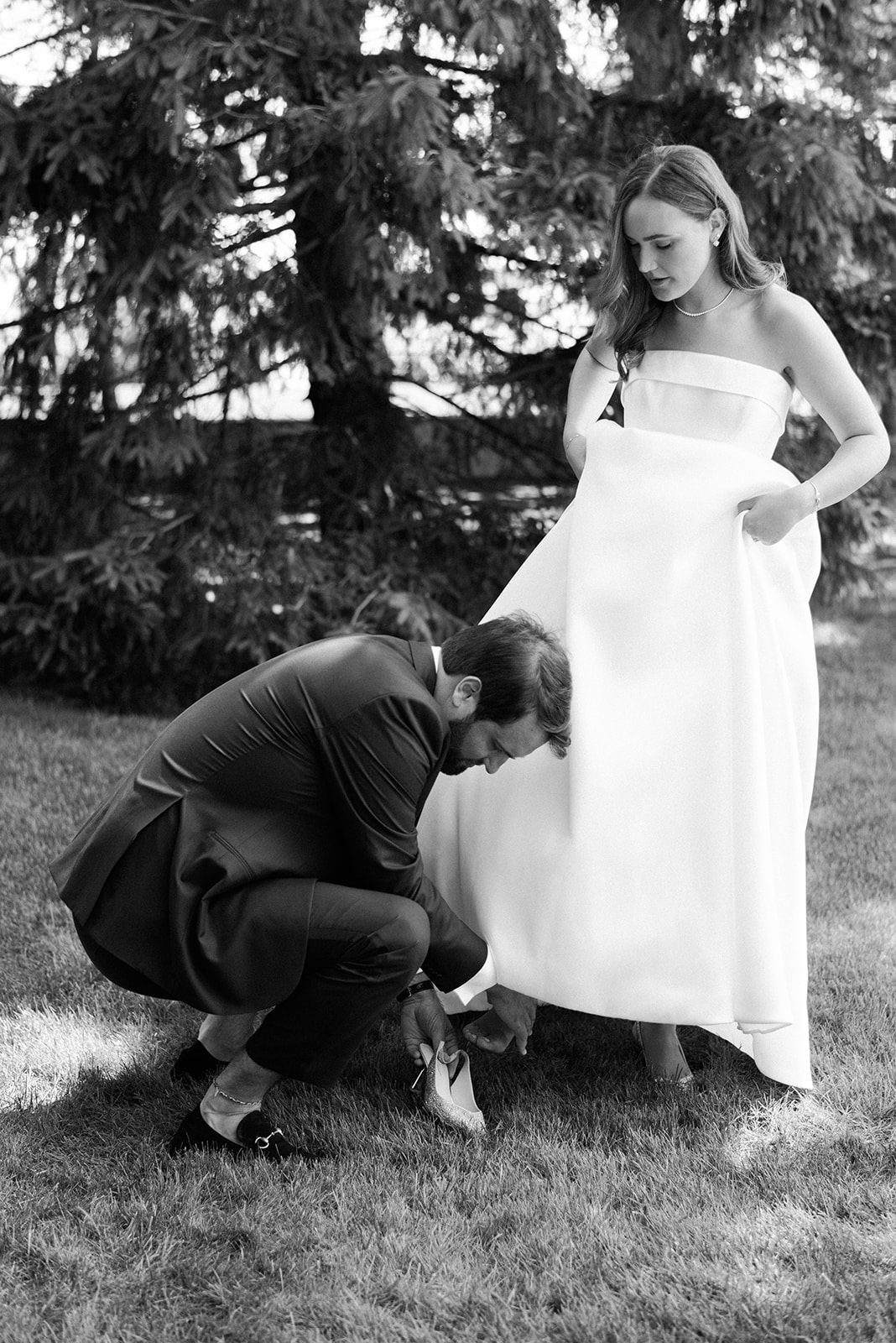 groom helping bride with shoes 