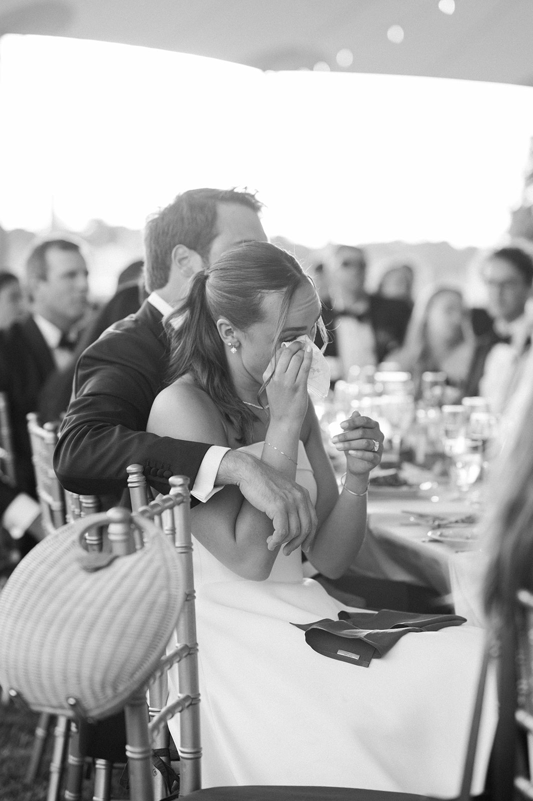 bride wipes away tears during wedding toasts