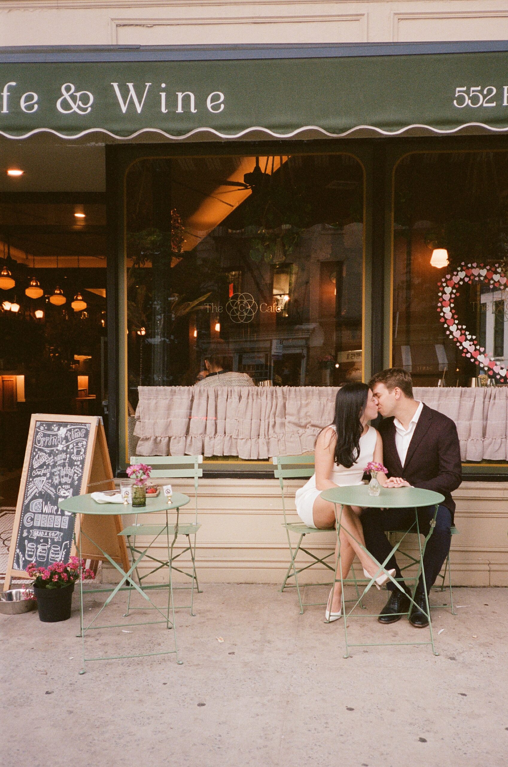Romantic engagement photos of couple sitting outside a cafe in West Village NYC