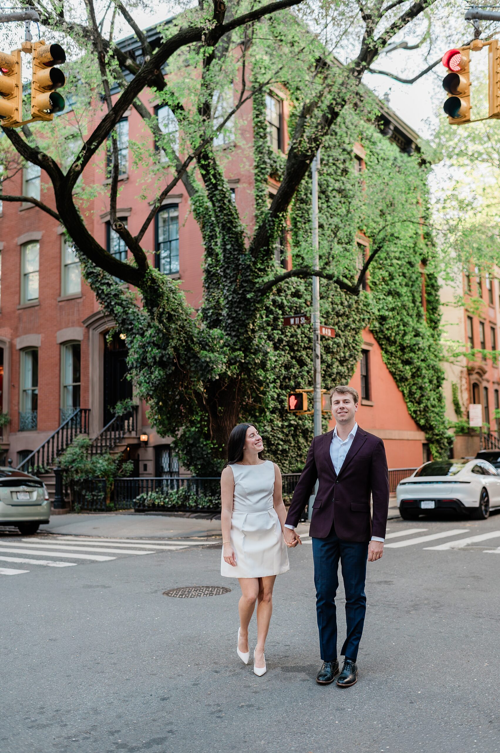 engaged couple hold hands as they cross in NYC