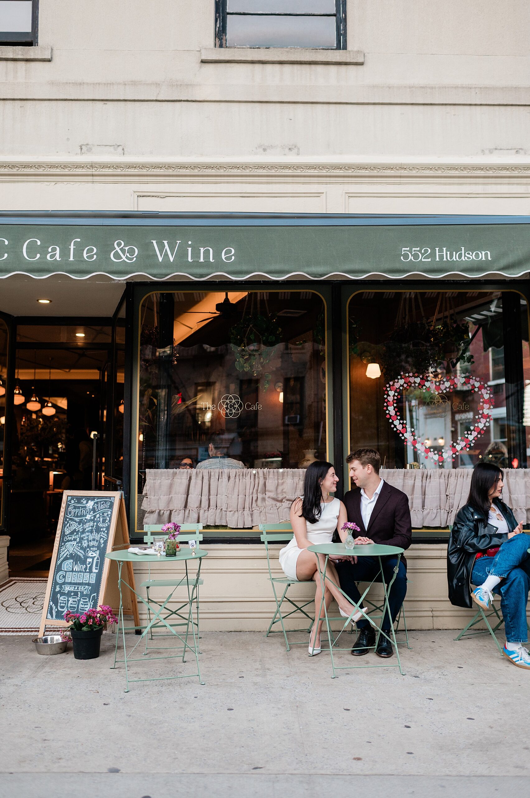 engaged couple sit outside at a cafe