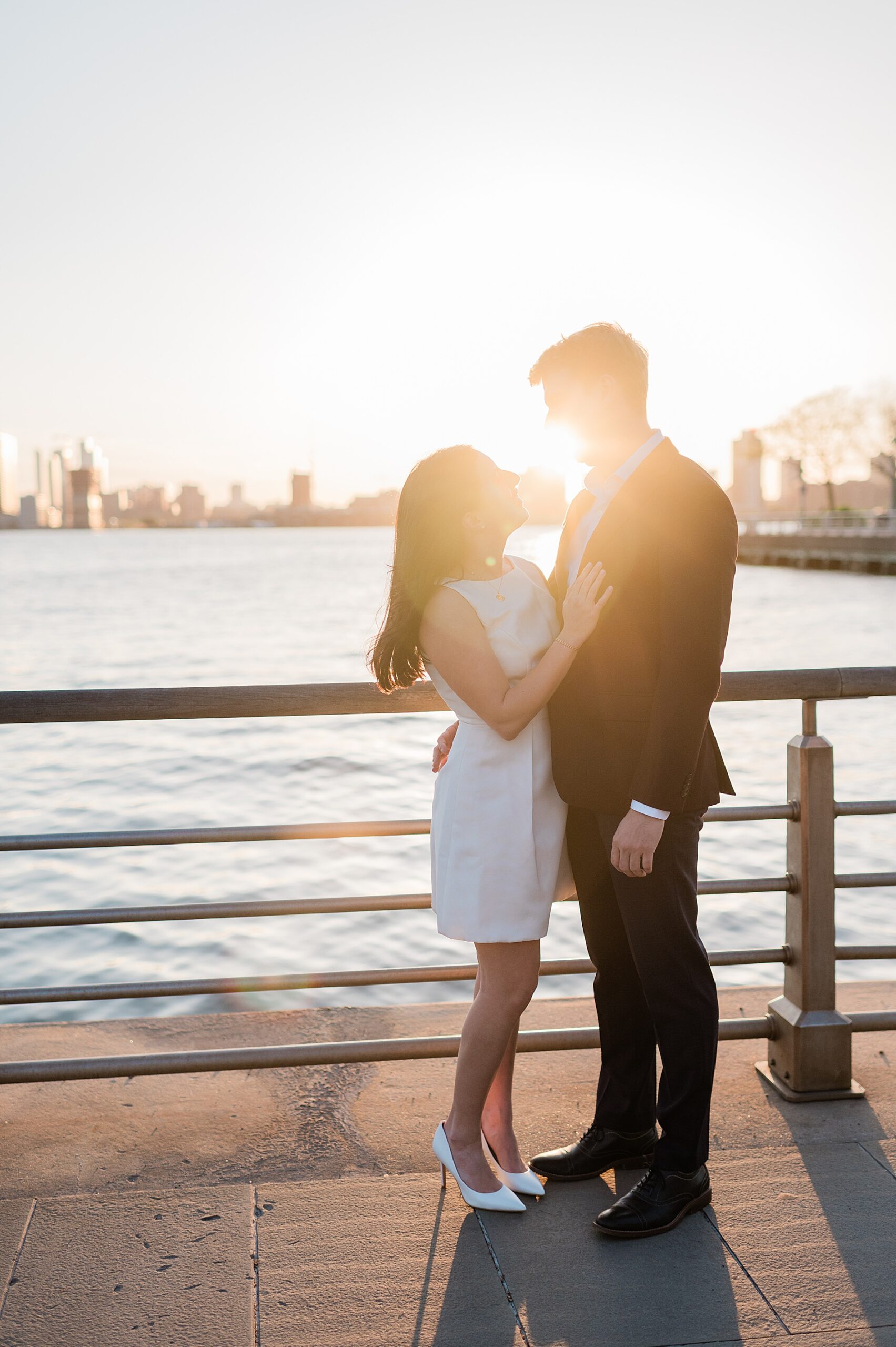 couple by the water with NYC skyline in the background