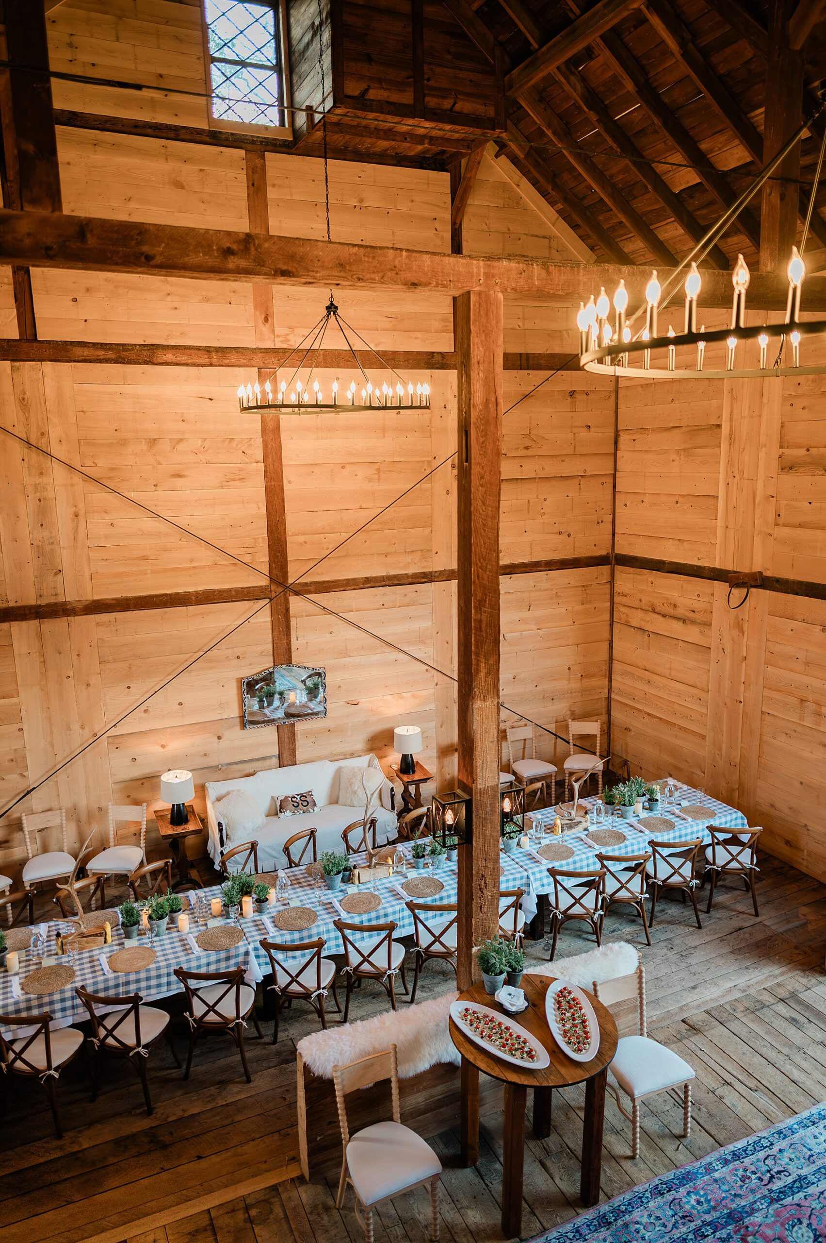 overhead view of barn with tables set up for wedding welcome party 