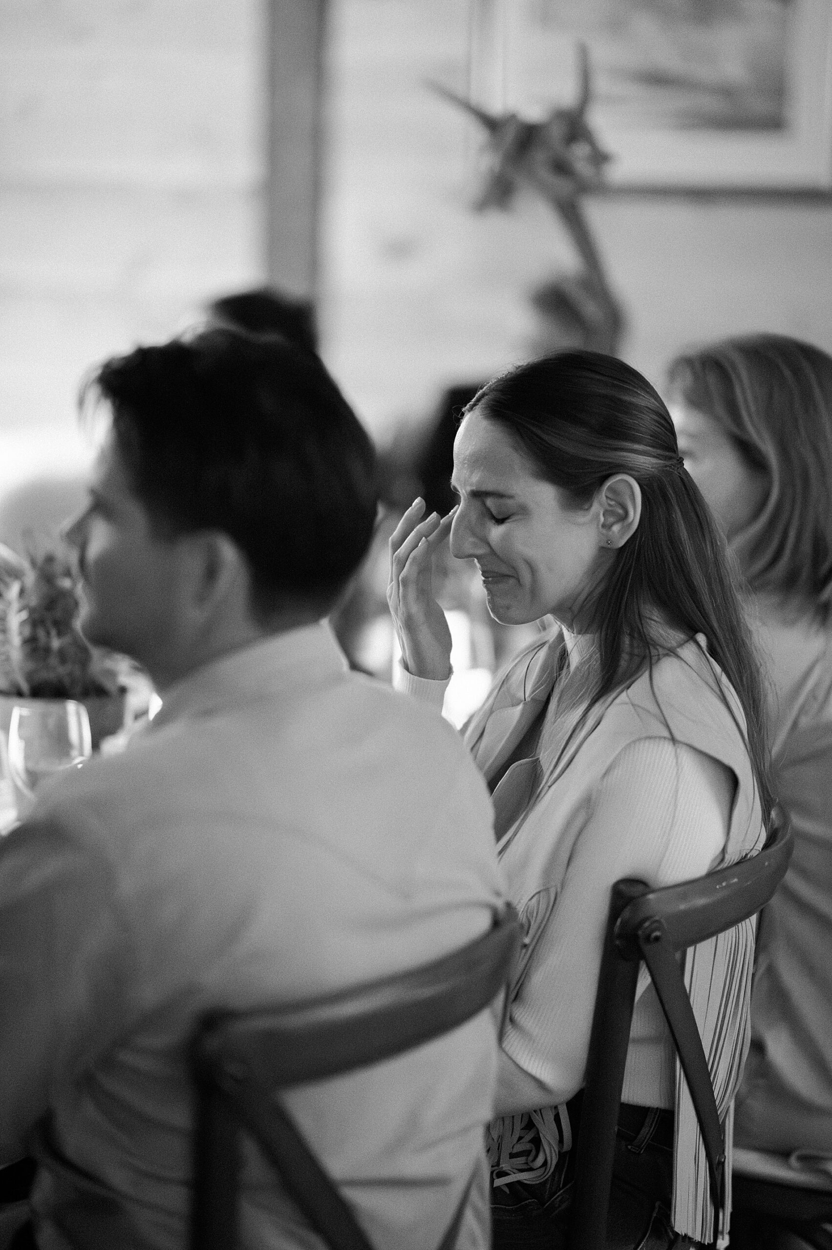 bride-to-be wipes away tears during speeches at welcome party