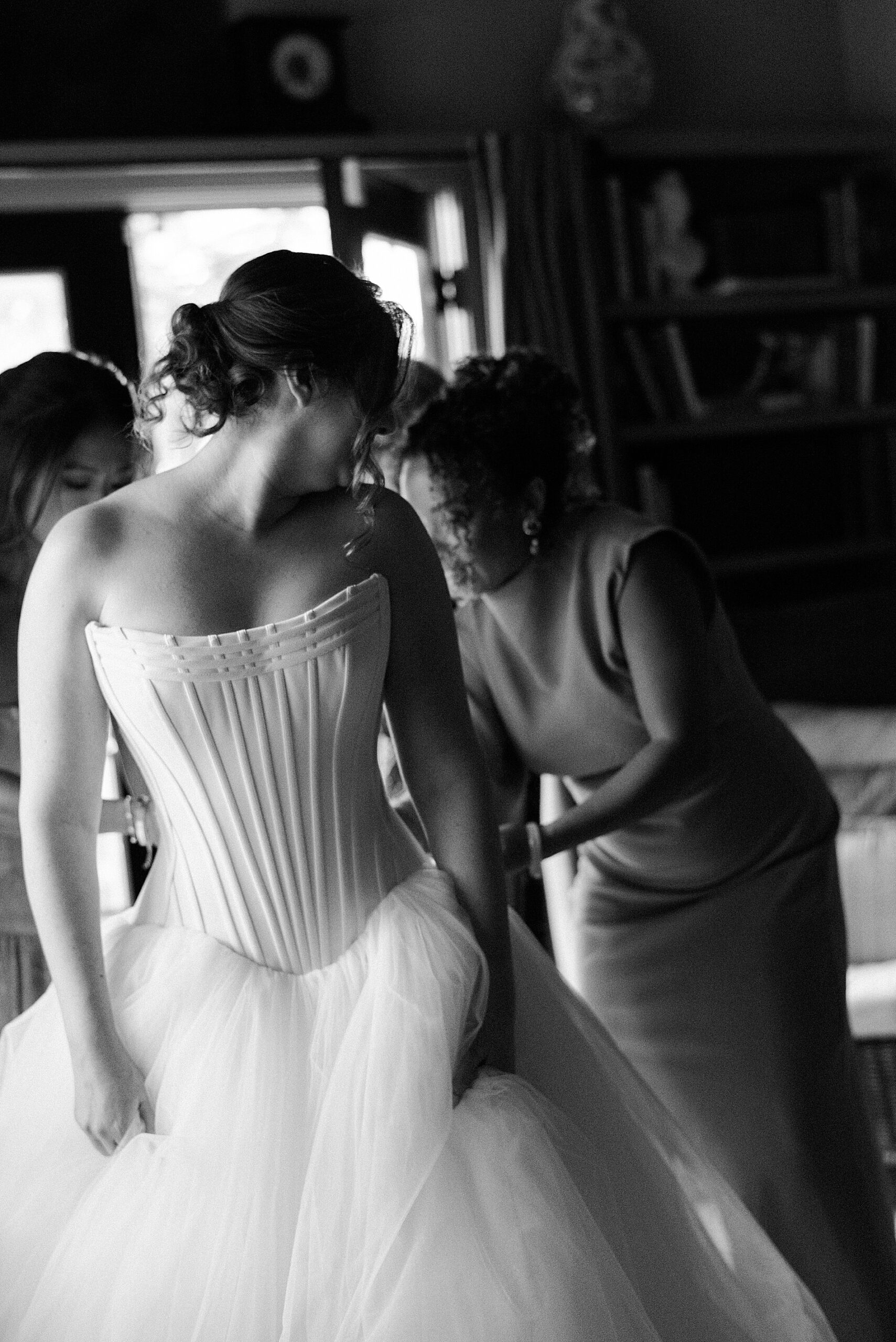 bride gets into wedding dress with help from loved ones