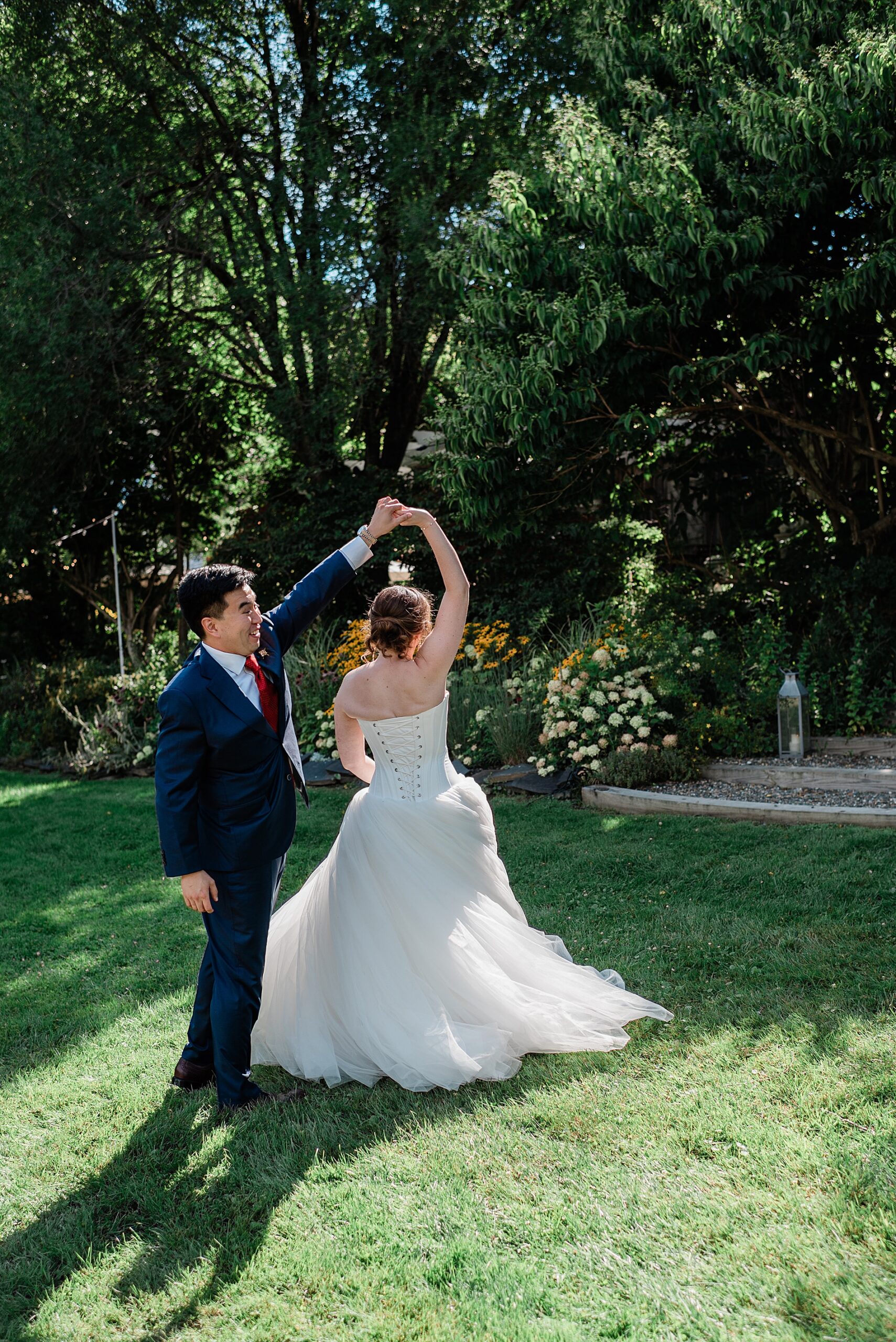 groom twirls bride in garden