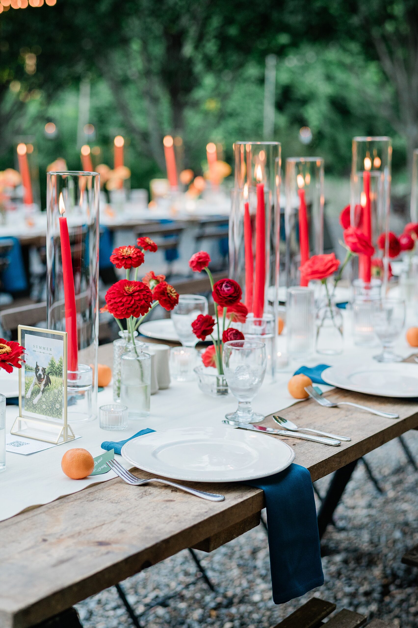 red flowers and red candles decorate reception table