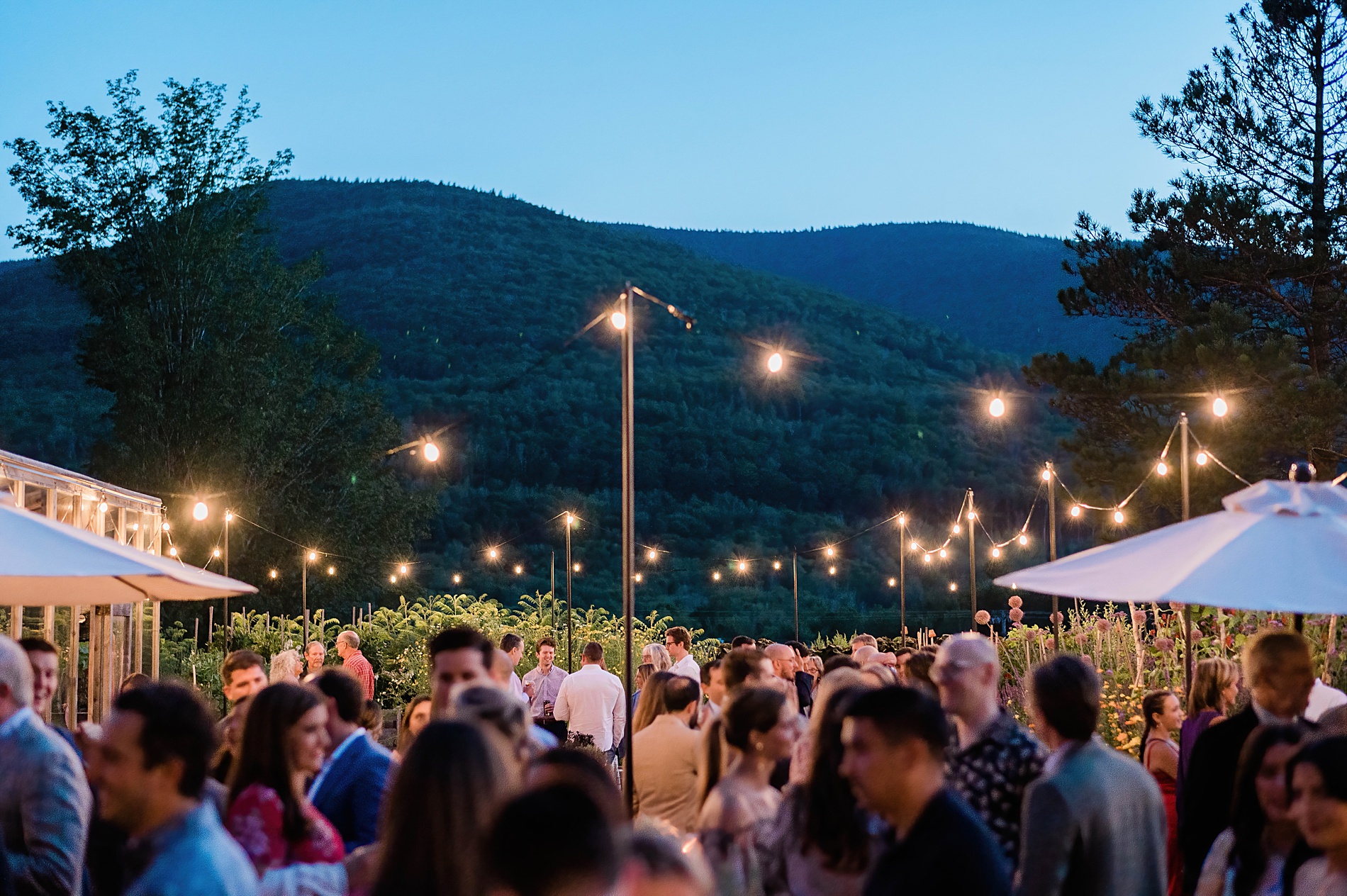 stunning mountain views are enjoyed as guests gather on patio of Scribner’s Lodge for outdoor wedding welcome party