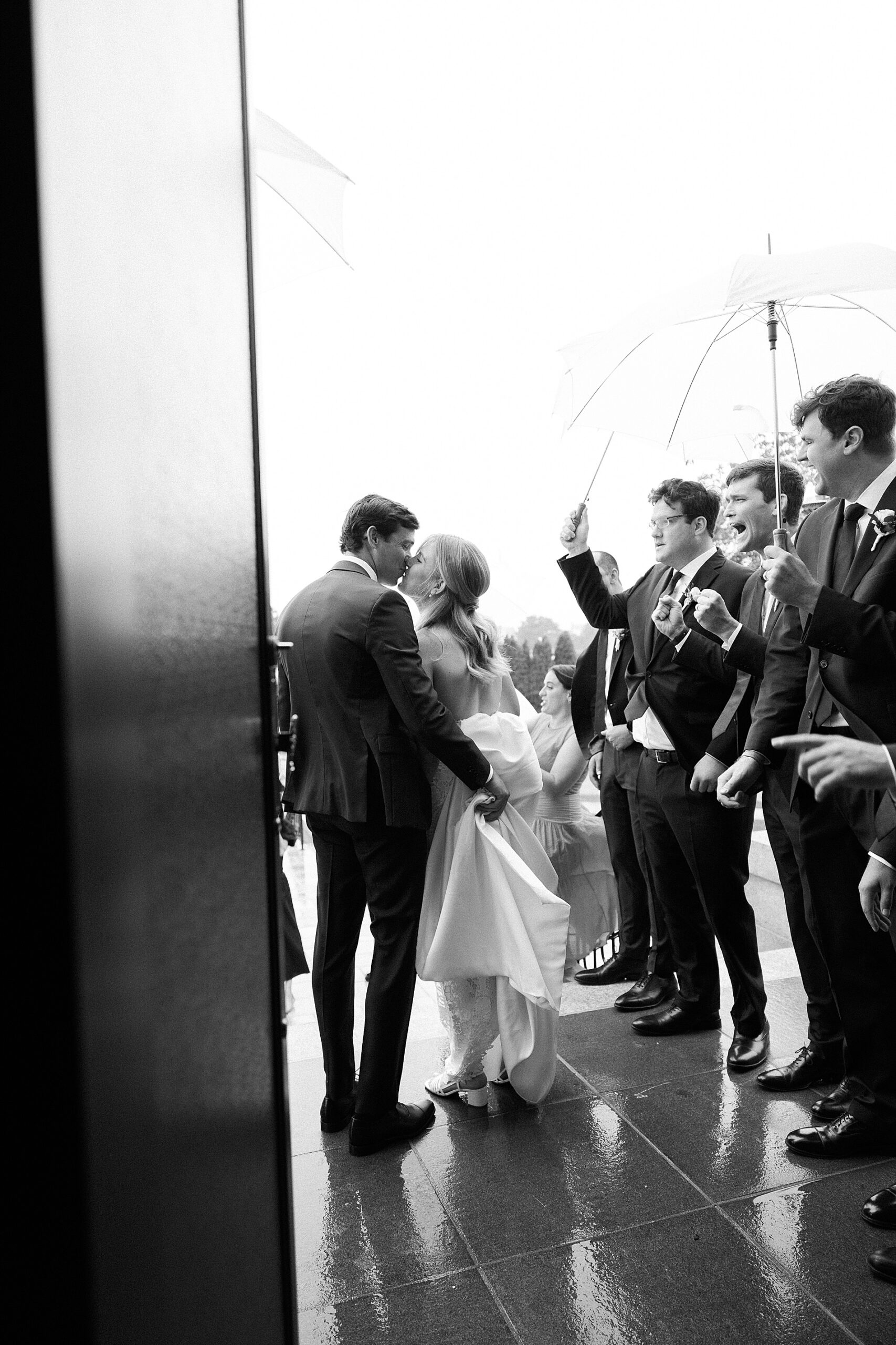 bride and groom kiss as they exit church at Rainy Spring Lake Wedding