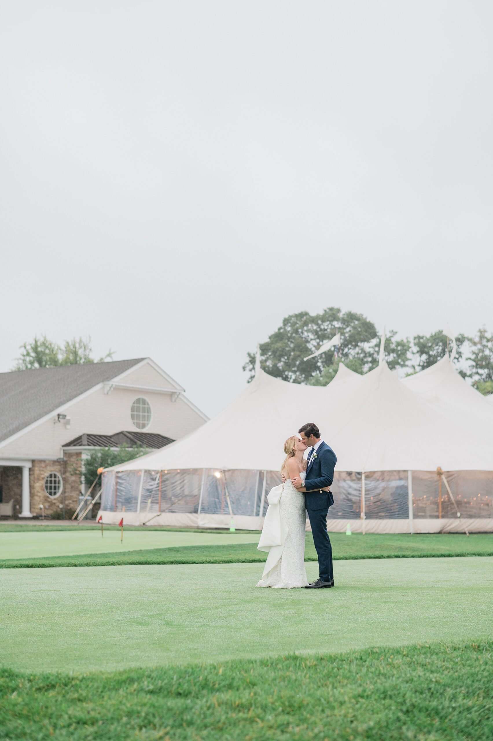 bride and groom kiss outside their sperry tent reception 