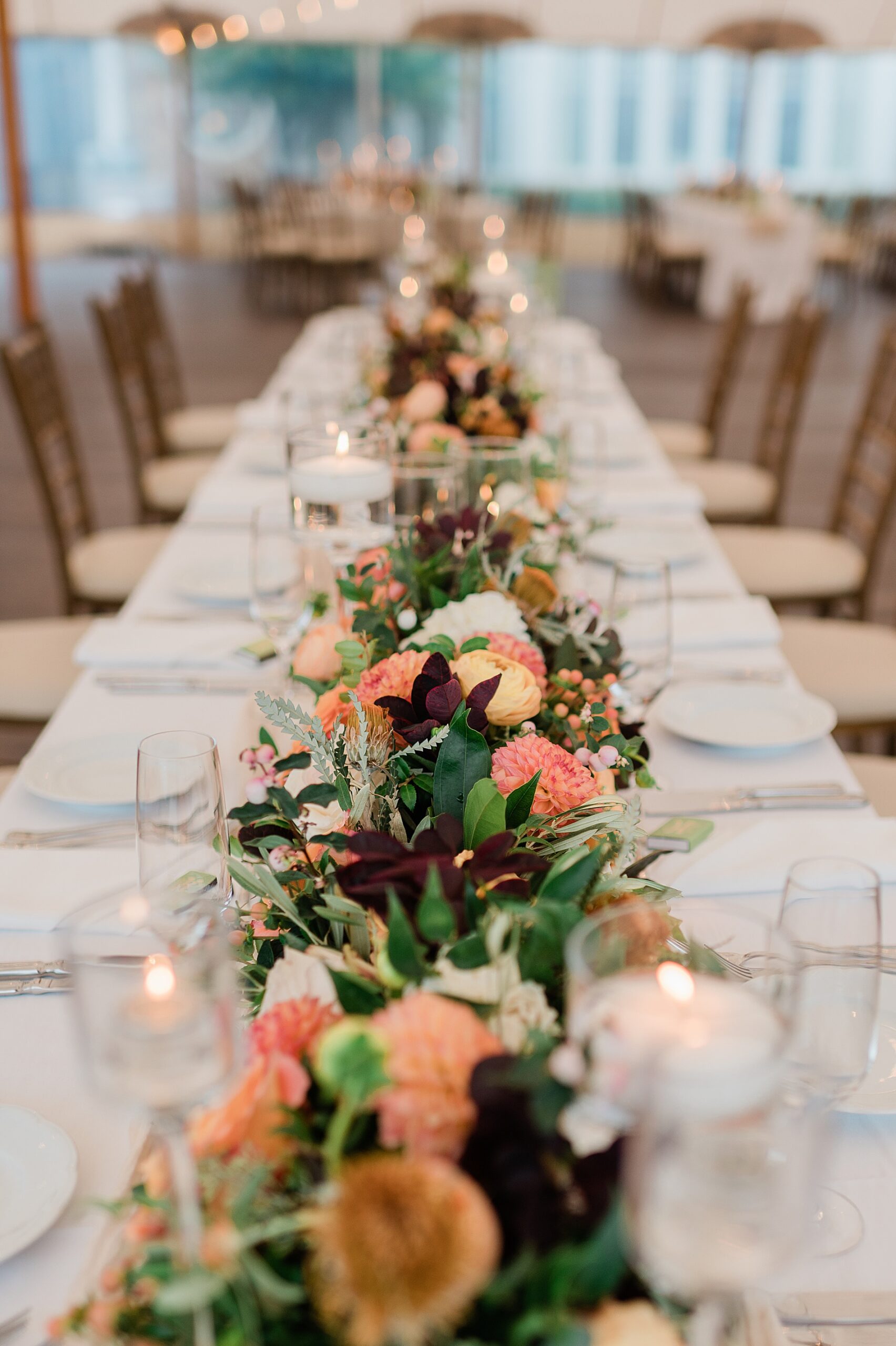 florals line center of long tables at Rainy Spring Lake Wedding