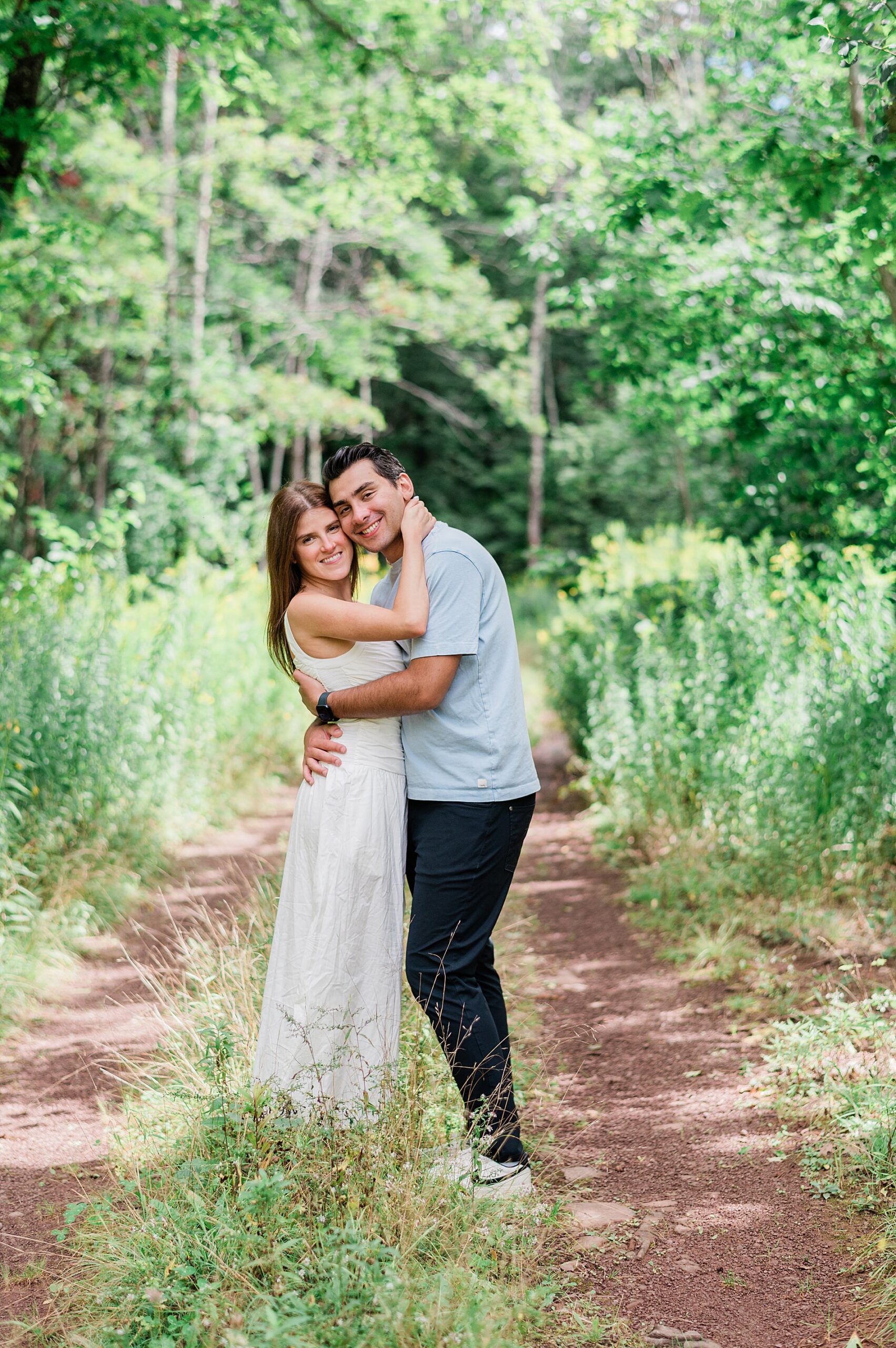couple hug on path in woods 