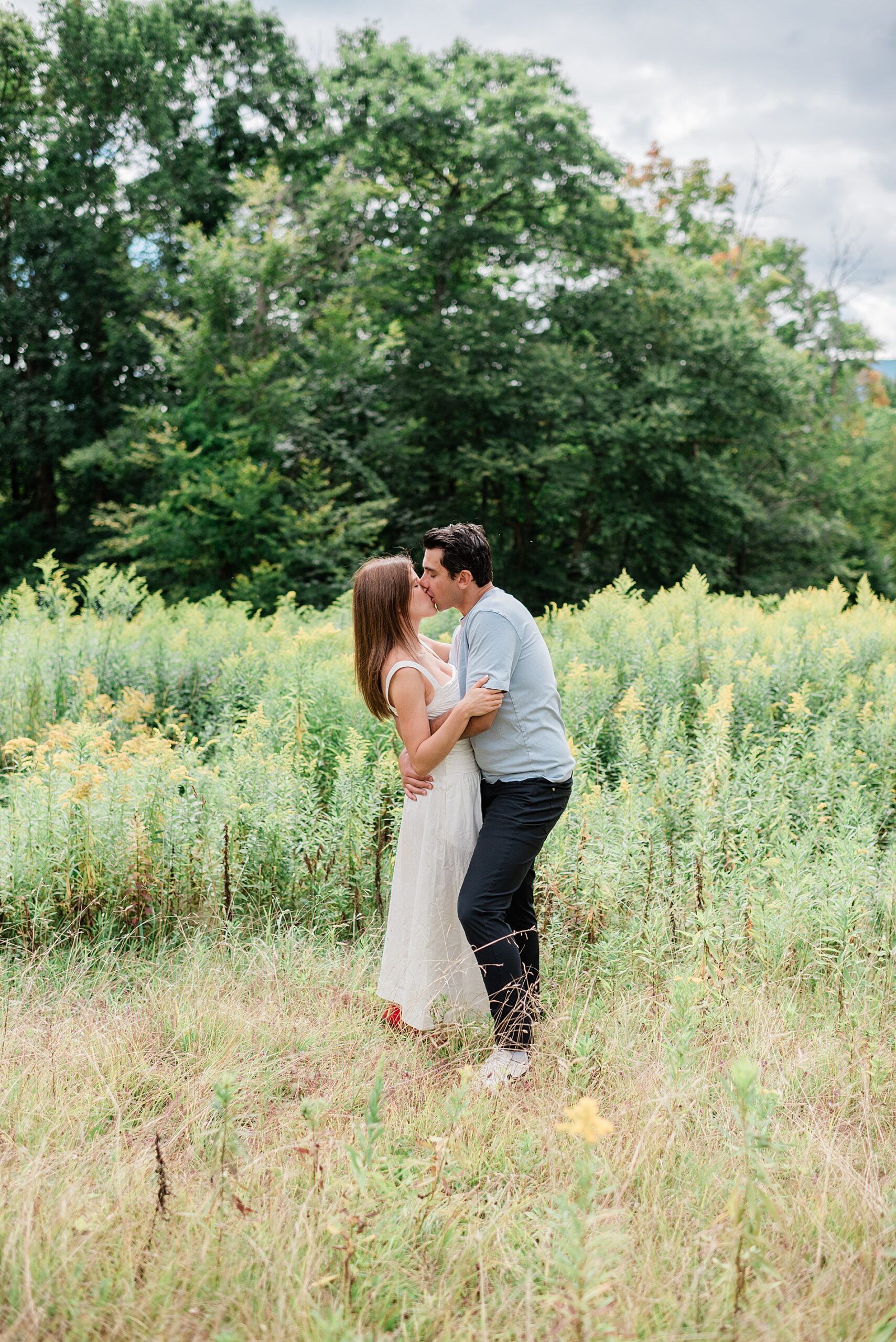 couple kiss in field of wildflowers 