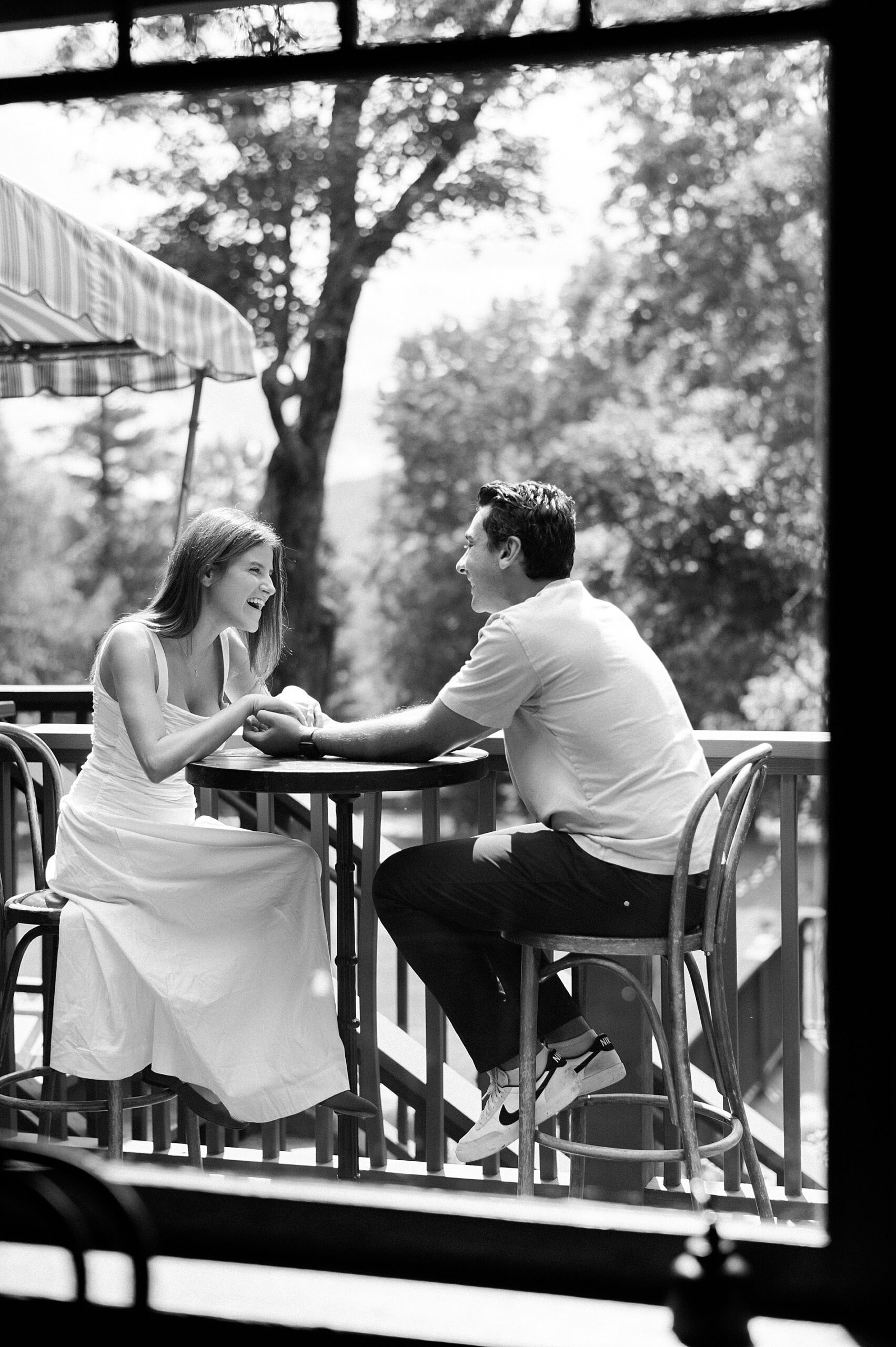 candid photo of couple laughing together outside on porch 